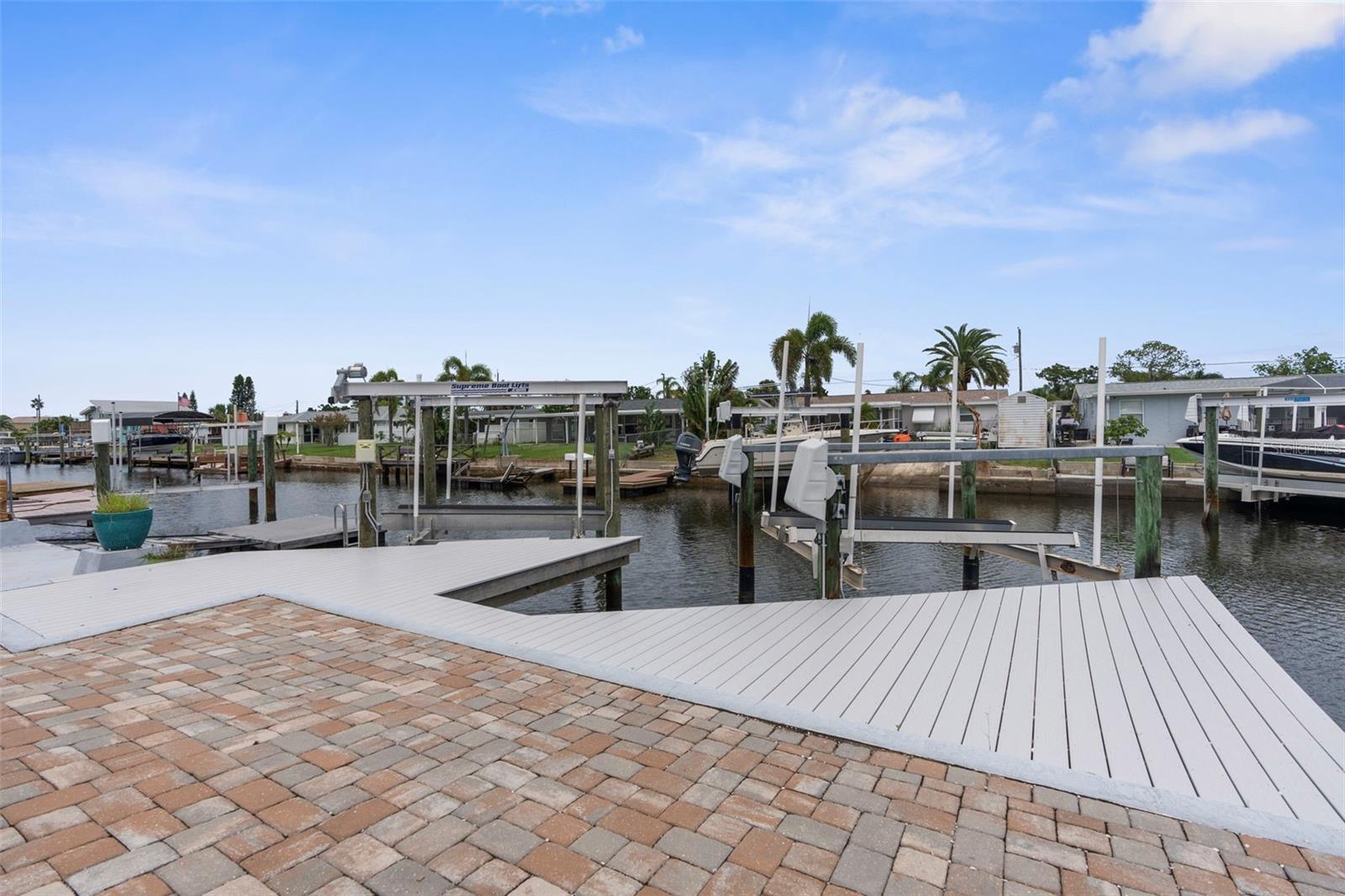 One or more photo(s) has been virtually staged. Your coastal dream home awaits! This home comes equipped with 2 boatlifts, and floating dock. Opportunity for extra income potential, rent one lift and use the other for yourself! The backyard is all brick pavers with a large covered patio, outdoor shower, outdoor stainless steel sink, and so much room to entertain. The exterior has minimal grass, so weekends are spent on the water instead of doing yard work. There are also 2 sheds in the backyard for additional storage for fishing rods, coolers, you name it! This home is spacious with updated light fixtures throughout, Softclose kitchen cabinets with a large lazy susan, granite countertops and appliances are only a fewyears old. The woodlike tile is carried throughout the home, no mismatched flooring and easy to maintain. This home is truly turnkey with a fantastic layout. The roof is from 2018 along with newer windows and hurricane shutters. Don't miss the opportunity to own this coastal gem, great for a priamry, vacation home or investment. Short idle to the Gulf, and easy to navigate. Passing 4-point inspection and wind mitigation available for the new owner!