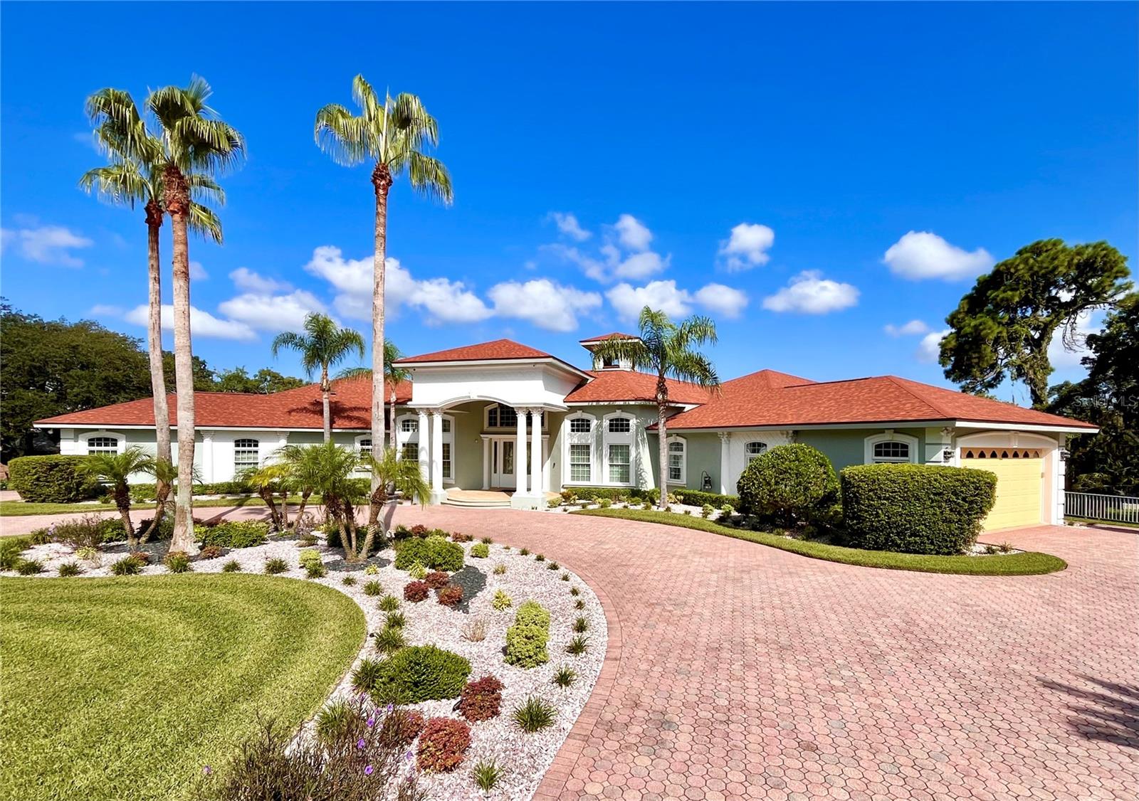 Welcome to this stunning lakefront estate on nearly an acre of professionally landscaped grounds. The estate sits on a spring-fed lake that backs up to a state nature preserve and is just three miles from the ocean. This custom-built masterpiece invokes the sophistication of an updated smart-home. It comes FULLY FURNISHED and has a BRAND-NEW ROOF (2025). You are welcomed through the double glass front doors by a stunning infinity lake view and fourteen-foot coffered ceilings which continue throughout the palatial interior. Marble flooring, marble walls, and quartz counters are just a few of the meticulous details. This home is the epidemy of a smart-home with a top-of-the-line Control4 home automation system. With a touch of your finger from your cell phone you can control the lights, motorized shades, whole house surround sound, TV’s, front door intercom/camera, AC thermostats, smart door locks, and exterior security cameras from anywhere in the world with an internet connection. This immaculate SINGLE-STORY retreat includes 5 bedrooms, each with their very own en-suite bathroom and walk-in closet. There is a great room, family room, sitting room/library, formal dining room, a home office with custom cabinets, a meditation room, and your very own exercise room. The master bedroom is for the most discerning of owners. It has a stunning view of the spring-fed lake, double trey ceilings, a mini bar with refrigerator, hardwood floors, a chandelier, as well as his and hers walk-in closets. The master bath has marble floors, soft close drawers, a freestanding soaker tub and a walk-in frameless glass shower with rain head plus multiple heads. Other distinctive features in the home include; Motorized shades. Cove lighting with various colors to suit your mood. Faux painted walls. Imported chandeliers. Four ecobee smart thermostats making it four-zone energy efficient. In the kitchen there is a sensor touch main sink, a second prep sink, a Sub-Zero refrigerator and an Insta-hot faucet. There are two gas fireplaces, both remote controlled. There is also a Tesla charging station in the garage. There are actually TWO two-car garages big enough for four cars, plus extra space for a golf cart or other toys. Outside offers privacy and luxury with a RECENTLY REMOLDED AND RESURFACED POOL (2024) that overlooks amazing sunsets on the lake. There is lanai with outside sink, outside surround sound, extensive landscape lighting, mature fruit trees, and over 1500 square feet of raised patio space. Located in the exclusive 24/7 guard staffed gated community of Lake in the Woods, which has tennis courts, pickle ball court, playground, and two lakes where canoes are allowed. Wild life abounds in this serene community; Turkey flocks, deer, ducks, egrets, sand hill cranes, ospreys, golden eagles, humming birds, and hawks. The community is conveniently located just 7 minutes to Weeki Wachee Springs State Park for kayaking and paddle boarding. 10 minutes to Hernando Beach for boating and deep sea fishing. 15 minutes to Pine Island Beach for swimming and sunsets. 45 minutes to the Tampa International Airport, and less than 60 minutes to St. Pete Beach, which was named the number one beach in America.