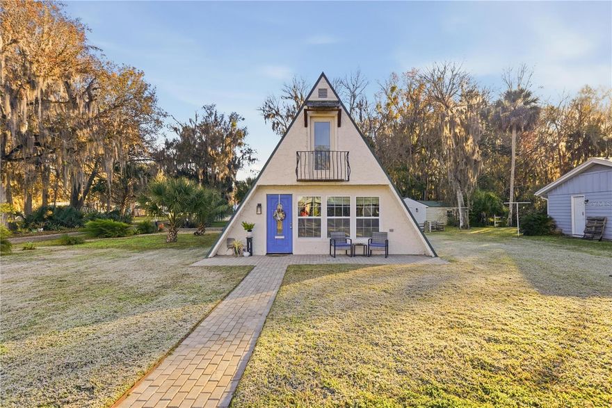 This fully remodeled, fully furnished A-frame with views of Lake George is an ideal vacation rental or personal retreat in peaceful Georgetown, Florida.Thoughtfully updated from top to bottom, this home blends modern finishes with timeless character and incredible indoor-outdoor living. The kitchen is a true showpiece, featuring beautiful shiplap walls, sleek modern appliances, and warm butcher block countertops. Tastefully selected tile flooring flows throughout the entire downstairs, creating a cohesive and durable living space. The primary bedroom and full ensuite bathroom are conveniently located on the main level, offering comfort and privacy. In the living room, a freshly painted spiral staircase with new treads leads upstairs, adding architectural interest and charm. The upper level showcases stunning hardwood flooring throughout, with luxury vinyl plank flooring in the half bathroom. Two upstairs bedrooms provide flexible living options—one private bedroom comfortably fits a full-size bed and includes a small closet and a window overlooking the backyard, while the second bedroom easily accommodates a full-size bed with additional space for a sitting area. Upstairs at the front of the home, a versatile flex space features an exterior door that opens to a balcony overlooking Lake George—an ideal spot to enjoy unforgettable sunsets and tranquil water views. Outdoor living is just as impressive, with a large screened-in back porch perfect for relaxing or entertaining, and a thoughtfully designed mudroom that provides a functional entry into the home. The property spans two lots totaling approximately 0.65 acres, offering privacy and room to spread out. Additional highlights include a whole-house propane generator (excluding AC), a 28 x 24 detached garage ideal for boats or RVs, and a separate laundry/storage building—perfect for hosting guests. Located with views of scenic Lake George, this home is surrounded by boating, fishing, kayaking, and abundant wildlife, making it a highly desirable vacation destination. Georgetown’s laid-back, Old Florida charm and stunning sunsets create an unforgettable guest experience, ideal for short-term rentals, weekend getaways, or seasonal stays. This one-of-a-kind Lake George property combines modern upgrades, generous space, and serene natural surroundings—perfect as a full-time residence or a peaceful getaway. Don't miss this opportunity to own this one-of-a-kind property in Old Florida!