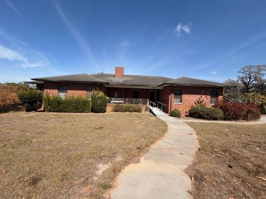 This property presents a remarkable opportunity, being zoned for both residential and professional use. The home features over 3,400 heated square feet, including four bedrooms, three full baths, and two half-baths. Situated on a 1.06-acre lot, it boasts road access on all four sides—245 feet along State Road 60, 152 feet each on 8th Street S. and Center Street, plus an alley running behind the house. The circular driveway is on the east side, with extra parking at the rear, an oversized parking pad, and a three-car garage complete with a workshop and a bonus room that includes a full bathroom.
A large side yard offers space for more parking or future expansions. Inside, the split-bedroom design creates privacy, while the open living area flows into a spacious dining room. The eat-in kitchen provides plenty of cabinetry and a butler's pantry with additional storage and a sink. Off the kitchen, the laundry room features a half bath and gives access to the detached garage. There are also two extra storage areas under the house, accessible from the backyard. Permitted uses approved by the City of Lake Wales allow for professional purposes as well. With its exceptional potential and unique location, this property stands out as a rare find.