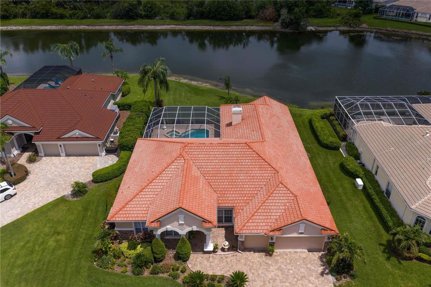 One or more photo(s) has been virtually staged. Experience luxury living in this former model home, masterfully crafted by Arthur Rutenberg and nestled on a premium waterfront conservation lot at the end of a quiet cul-de-sac in Arbor Greene’s beautiful, gated Enclave village. From its barrel tile roof and stacked-stone accents to the freshly sealed paver driveway and lush landscaping with custom lighting, this home exudes elegance and curb appeal. This impeccably maintained residence offers 4 spacious bedrooms, a dedicated home office, a large family room with fireplace, 3.5 baths, a custom-built home theater/bonus room, and a 3-car garage. Architectural details abound with soaring ceilings, columns, archways, crown molding, rounded corner beads, plantation shutters, paddle fans, and rich wood and tile flooring throughout—no carpet. Enter through double glass doors into a grand foyer that opens to a stunning formal living room with sliders that fully pocket, seamlessly connecting indoor and outdoor spaces. The formal dining room is ideal for entertaining, while the spacious office with adjacent powder bath and storage closet adds functionality and charm. The chef’s kitchen is a showstopper with granite countertops, 42-inch maple cabinetry with pull-out trays, tiled backsplash, double convection ovens, oversized island with snack bar, a long breakfast bar, recipe desk, walk-in pantry, and a cozy dinette that overlooks the pool and pond. The oversized primary suite offers tranquil pool and water views, dual walk-in closets and a spa-like bath with Roman soaking tub, step-in shower, split vanities with granite counters, and abundant cabinetry. Secondary bedrooms are generously sized and include a Jack-and-Jill bath with granite counters and ample closet space. The custom home theater features a high-definition projector, 120-inch screen, motorized reclining chairs, and tiered seating—perfect for movie nights or entertaining guests. Step outside to a true backyard oasis: a resort-style heated saltwater pool and spa (recently resurfaced with new variable-speed motor), covered lanai, and a fully equipped outdoor kitchen with Dynasty gas grill, dual burners, granite counters, sink, and refrigerator—all framed by serene pond and conservation views. Additional highlights include a full wall of built-in storage in the 3-car garage, updated A/C units (2016 & 2021), and custom wainscoting throughout the main living areas and bedrooms. Located within one of New Tampa’s most sought-after gated communities, Arbor Greene offers a vibrant lifestyle with a clubhouse, two resort-style pools, fitness center, tennis courts, pickleball courts, playgrounds, miles of walking trails, and 24 hour manned, gated access. This is a rare opportunity to own a custom, move-in-ready home with every upgrade imaginable in one of Tampa’s most desirable neighborhoods. Some rooms have been virtually staged for inspiration.