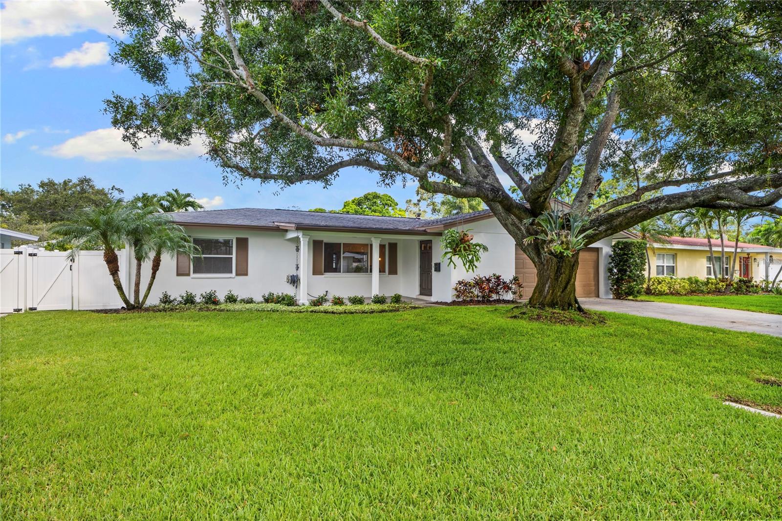 One or more photo(s) has been virtually staged. Located under the canopy shade of a majestic oak in the highly desirable neighborhood of Patrician Point, this beautifully updated 1960s block ranch combines timeless charm with modern living. Just minutes from downtown St. Pete and popular spots like Crisp Park, Trader Joe’s, Whole Foods, and the waterfront shops & restaurants of popular Beach Drive & Central Ave, this home offers both convenience and lifestyle. Inside, you're welcomed by brand new white oak luxury vinyl plank flooring that flows seamlessly throughout the entire home. The open concept layout is perfect for entertaining, centered around a chef-inspired kitchen featuring quartz countertops, coastal shaker cabinetry, a subway tile backsplash, breakfast bar with built in beverage fridge and abundant storage.
The smart split bedroom floor plan provides privacy and comfort with a spacious primary suite featuring a fully renovated en-suite bath complete with dual marble-topped vanities, a walk-in tiled shower and glass enclosure. Step outside to enjoy true Florida living in the large fenced backyard with new PVC fencing, a covered patio ideal for BBQs, room for a pool and space for pets or little ones to play.
Additional upgrades include a tankless gas water heater (2019) and attic insulation (2019) for improved energy efficiency. Located in a non-HOA, golf-cart-friendly community, this move-in-ready home is perfect for those seeking the ultimate St Pete lifestyle. Don’t miss your chance to own a piece of St. Petersburg paradise!