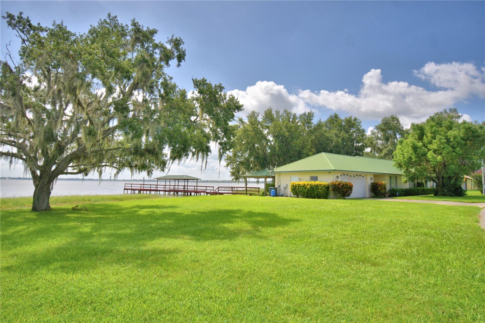 Welcome to the Lake - 3 Bedroom, 2 Bath on Lake Reedy, FAA approved for Sea Planes . Mother In Law suite POSSIBLE with garage conversion. What an amazing home. Metal roof, Laminate & tile flooring and amazing views thru a wall of windows looking over the water. The open concept creates a shared space and is perfect for gatherings with the kitchen flowing into the dinette area and seamlessly joining the living room all with views of the lake. Galley kitchen, tall counters perfect for extra bar stool seating. Split floor plan, the master has walk in closet, en-suite bathroom with double sinks, tall counters, walk in shower with beautiful tile insets and assistance bars. The laundry room/closet has tile floor and Washer and Dryer that will stay with the home. 2nd and 3rd bedrooms ore split by a nice size full bath with tub shower combo. Screened Lanai just outside the kitchen allows for peaceful mornings and restful afternoons looking out over the water. Double garage and new dock that is 110 feet long with 16X21 landing/fishing platform, hand rail, jet ski ramp, boat slip that will accommodate a pontoon with cross beam in case a lift is wanted and 340' of seawall. Sunrise is breath taking from the dock, the lanai or inside as you can see from the photos, the breeze is refreshing and the fishing in this lake is well known in this area. She shed is decked out and pergola with lounger is where naps are a must. Public boat ramp a short distance away with floating dock and facilities. Centrally located between both coasts with easy access to Tampa and Orlando airports, Disney, Legoland and so much more. This property is a rare gem. Schedule your private tour today and make this your forever home.