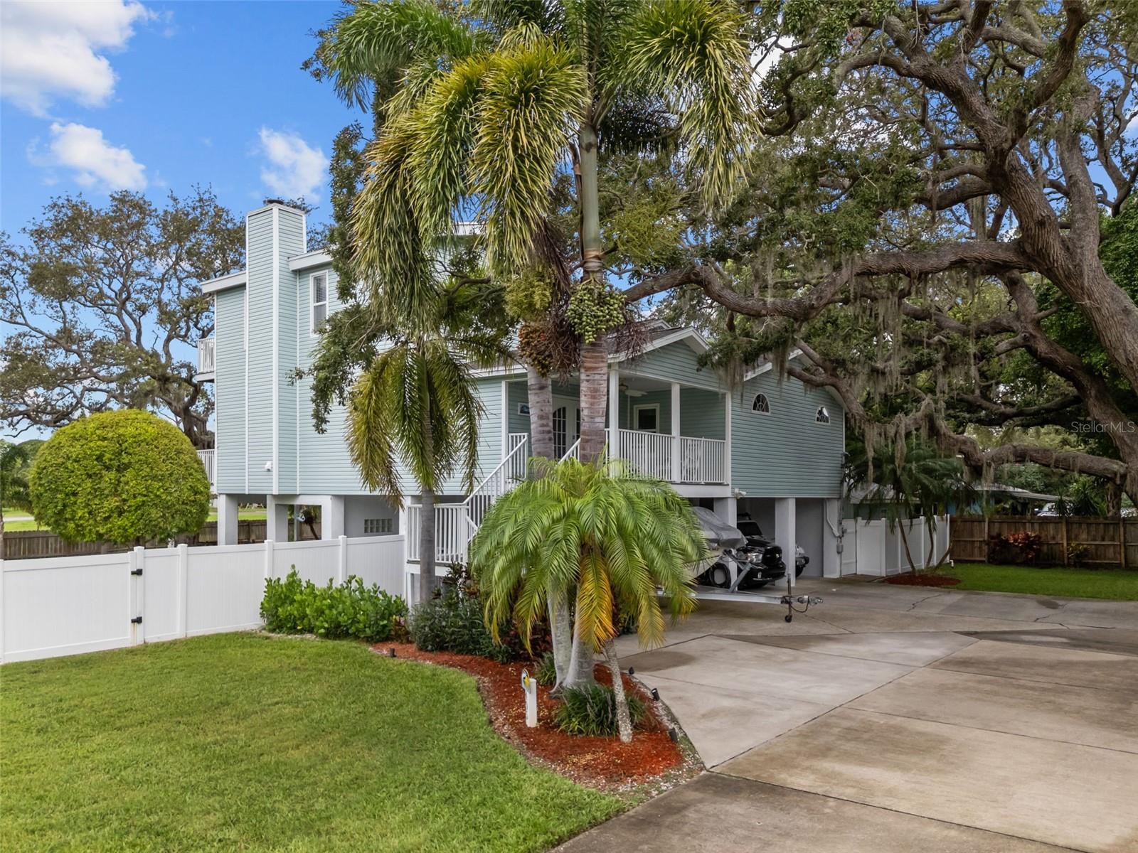 Welcome to 405 Charleston Avenue – A Custom Key West style retreat in Crystal Beach. Tucked away in a tranquil enclave of sought-after Crystal Beach, this stunning tri-level home offers the perfect blend of coastal charm, privacy, and panoramic views. Thoughtfully designed and impeccably maintained, this custom-built residence captures the essence of Florida living with over 2,600 square feet of stylish, functional space. Step into the grand second-floor foyer, where natural light floods the open-concept living area through large windows. The updated kitchen is a chef’s dream, featuring granite countertops, solid wood cabinetry, and bar seating—ideal for both entertaining and everyday living. The spacious dining and living rooms flow seamlessly into a cozy family room complete with a custom-built bar. French doors lead to an expansive wraparound porch, creating the ultimate indoor-outdoor lifestyle. This level also includes two guest bedrooms and two full bathrooms, including a private en-suite—perfect for family or visitors. The entire third floor is dedicated to the luxurious primary suite, boasting vaulted ceilings, oversized windows with stargazing views, and a private balcony for relaxing in total seclusion. The tropical backyard is a true oasis, highlighted by lush landscaping, a sparkling saltwater pool, covered entertainment area, and a fully equipped outdoor kitchen. On the ground level, you'll find a half bath, generous indoor storage/workshop, and a versatile 21' x 12' bonus room currently used as a home gym. Additional features include extensive under-house storage, a separate shed, and a large side yard ideal for boat or RV parking. With an adjacent unbuildable lot providing extra privacy, this home is perfectly located just minutes from the Crystal Beach Pier, scenic parks, and only 2 miles from downtown Palm Harbor’s vibrant shops, dining, and community events. Don't miss your chance to own this exceptional piece of paradise—schedule your private showing today! Professional Virtual Tour Available.