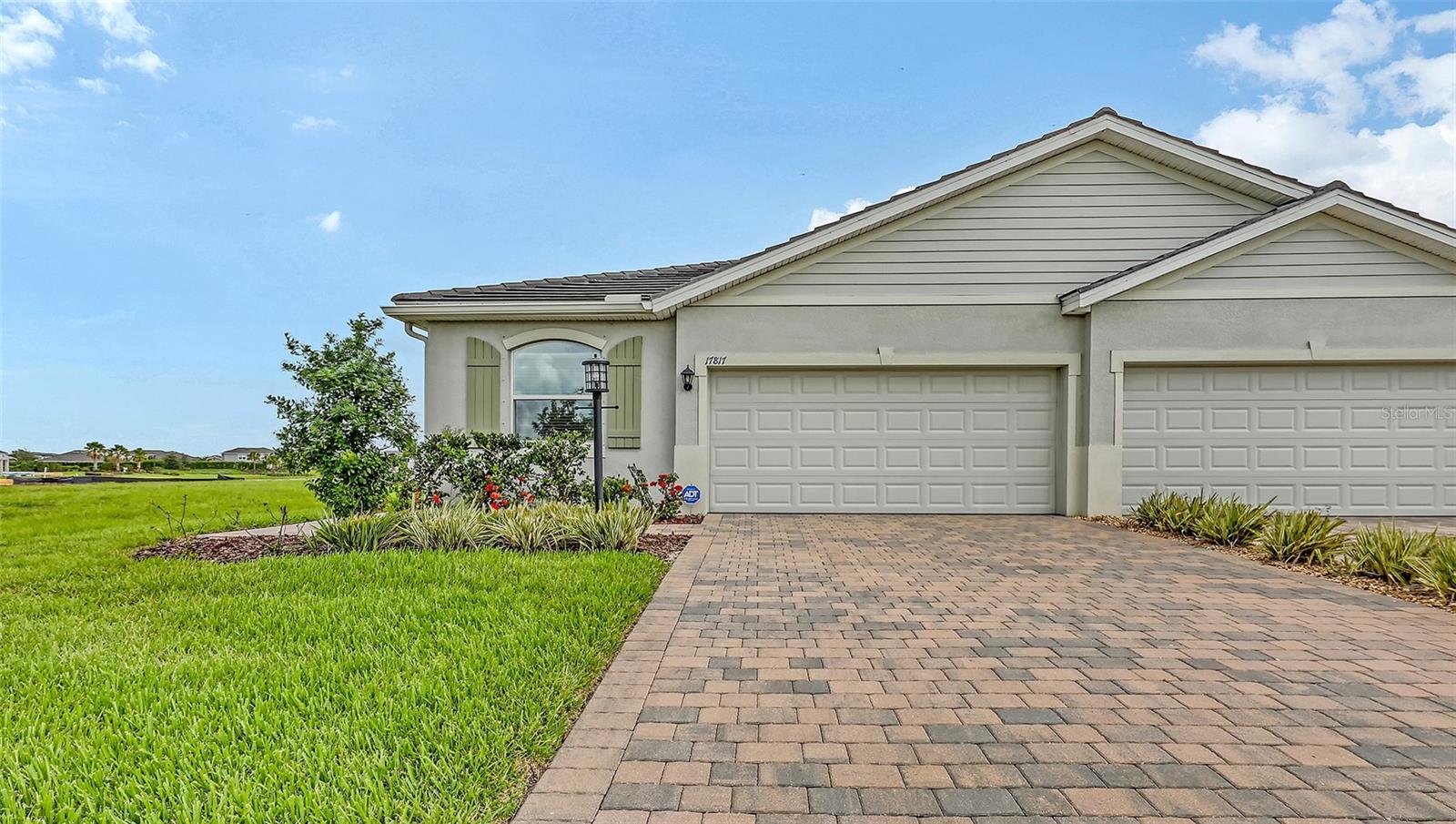 Experience resort style living in the spectacular, gated and amenity-rich, Star Farms at Lakewood Ranch. Located in the exclusive, active adult lifestyle Adventure community, this rarely used, meticulously maintained, 3 bedroom, 2 bath, maintenance-free attached villa, sits on a prime waterfront homesite. The paver driveway and walkway lead to the entry of this quaint villa. A truly open concept, the bright and airy split floor plan features gorgeous tile flooring in the main living areas and granite countertops throughout. The spacious kitchen features a large island breakfast bar, walk-in pantry and wood shaker style cabinets overlooking the great room and adjacent dining area. Enjoy the tranquil pond views from the great room and adjoining screened lanai. The split bedroom plan offers a sizeable primary bedroom with water views, tray ceiling, walk-in closet and ensuite bath with dual sinks and walk-in shower. The guest bedroom is tucked privately away with plush carpeting, ample closet space and nearby full bath and tiled tub/shower. French doors open to the 3rd bedroom that can easily be utilized as a den/office, perfect for working remotely. Its spacious walk-in closet is great for extra storage. Life is made easy with state-of-the-art SMART Home Automation System providing security and peace of mind. The two car garage is finished with epoxy flooring and offers plenty of room. Updates by the owners include ceiling fans in the primary bedroom, guest bedroom and lanai, screen enclosure of the lanai and epoxy flooring in both the garage and lanai. Residents of the Adventure neighborhood enjoy exclusive access to the amazing Adventure Retreat, a social center geared to the needs and lifestyles of the active adult. Included are a private clubhouse with meeting rooms, a resort pool, spa, cabanas and beach area, tennis and pickleball, bocce ball, resistance pool, poolside grilling area, pet park and fitness/wellness center. Also available to Adventure residents is The Resort Club and Cabana Corner. The Resort Club offers a resort style clubhouse, Star Fit fitness center with golf simulator, exercise classes, large pool and spa with poolside cabanas and beach area, a coffee shop, a poolside bar & grill, basketball courts and baseball field, sand volleyball and flex lawn. The Cabana Corner will feature a resort pool, poolside cabanas, outdoor grilling area and pet park. Star Farms is conveniently located to airports, great restaurants and abundant shopping, championship golf courses, world class beaches and leading medical facilities. Enjoy the best of Lakewood Ranch living! This is a must see home. Schedule your private tour today!