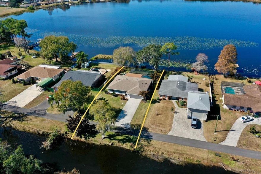 Lakefront living with a proper sunset! Down a private road with no HOA (because your house shouldn't come with a rule book). This renovated home offers direct frontage 80' on Lake Pansy and a bonus 80' of canal frontage across the street. The property provides excellent water access and endless sunset views.

Outside is where this home really shows off with amenities including a heated saltwater pool / lap pool with markers on the bottom,  lighting and water features, added style with a surfboard outdoor shower, screened in with panoramic panels because this view deserves center stage. The outdoor summer kitchen is outfitted with a refrigerator, table top ice chest, bar area, and a grill supplied by a 99-gallon propane tank, making it well-suited for entertaining all year round.

The lanai is glassed in with cedar tongue and groove ceiling wrapped with motorized retractable sunshades, while enhanced landscape lighting and mature palm trees set the tropical tone. Additional exterior upgrades include a composite dock, fenced in yard, seamless gutters with leaf filters, and recently replaced garage and front entry doors.

Inside, the vibe continues with an electric fireplace with customizable lighting (because ambiance matters). Live-edge floating shelves with integrated lighting adds a designer touch. Double-pane replacement windows, custom drapes, California Closets, luxury vinyl and ceramic tile throughout, laundry closet for added convenience. The kitchen brings the function and the flair with an island, generous storage, new cabinetry, quartz countertops, a natural gas range with hood ventilation, along with a built in microwave, electric oven, and refrigerator/freezer. Culligan water treatment.

The roof and HVAC system are approximately 10 years old. Additional features include LRE foundation improvements, and well-fed irrigation. Prewired generator hook-up installed in garage.  The boat ramp is located on the west side of lake Pansy.

This is a rare opportunity to own a turnkey lakefront property with endless sunsets, extensive upgrades, and no HOA restrictions.