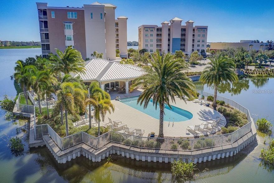 HUGE PRICE REDUCTION! 50K! This rare end-corner unit is within the waterfront at main street is situated at the heart of Lakewood Ranch! Location, Location, Location. 
The unit includes an assigned parking and a storage unit  in the the building. Expansive hurricane-impact windows and sliding doors thought out allow abundant natural light while showcasing peaceful lake views. A spacious screened balcony extends your living area outdoors, providing the perfect setting for morning coffee, evening gatherings, or quiet reflection with a water backdrop. The home also offers a large laundry room with extra space for storing household supplies, cabinets, and a utility sink with folding area. U-shaped kitchen with a breakfast bar provides ample wood cabinet storage boasts quartz countertop, double oven, monogram stainless appliances. Whether you’re cooking for yourself or entertaining guests, the kitchen flows seamlessly into the family room. High ceilings, crown molding and ceiling fans, enhance the open floor plan overlooking the lake view.
The master suite offers direct access to the balcony, allowing you to wake up to stunning views of Lake Uihlein. The suite includes a well-sized master bathroom boasting dual sinks, a walk-in shower with a frameless glass door, a modern cabinet tower providing ample storage, and an enclosed toilet room. Two additional bedrooms, each with their own closets and easy access to a second full bath, provide plenty of space for family, guests, or a dedicated office.
The gated waterfront condo offers resort-style amenities, including saltwater pool, spa, outdoor kitchen with grill and sink, on-site manager, and fitness center. Also with the CDD already paid off, new owners only pay $176 annually. This well-maintained condominium features secured access to both the gate and the building. With the added benefit of an adjoining 153-acre private Lake Uihlein, offering serene views, bird watching, direct access for kayaking and canoeing, and ramps for boating and recreational vessels.
Step outside the gates, and you can stroll to stylish boutiques, international restaurants, and the open-air plaza known for hosting events, concerts, festivals, and farmers’ markets. Lakewood Ranch’s Main Street is also home to Starbucks, yoga and barre studios, and other fitness centers. Enjoy dining out with family or entertaining guests at Lakewood Ranch Cinemas, The Fish Hole miniature golf, or restaurants such as Ed's Tavern, Paris Bistro, and Pinchers Crab Shack.
The proximity to Downtown Sarasota, Sarasota International Airport, renowned beaches, rivers, state parks, hospitals, shopping malls, universities, and various golf and country clubs makes Lakewood Ranch one of the best multi-generational communities in the country. Just one exit away, you’ll find Siesta Key Beach, Lido Key Beach, Ringling Museum, Marie Selby Botanical Garden, Sarasota Opera House, and St. Armands Circle. Sarasota Bradenton International Airport is only 18 minutes away, while the Manatee River, Anna Maria Island, and Costco are just a short drive (two exits) from the community.