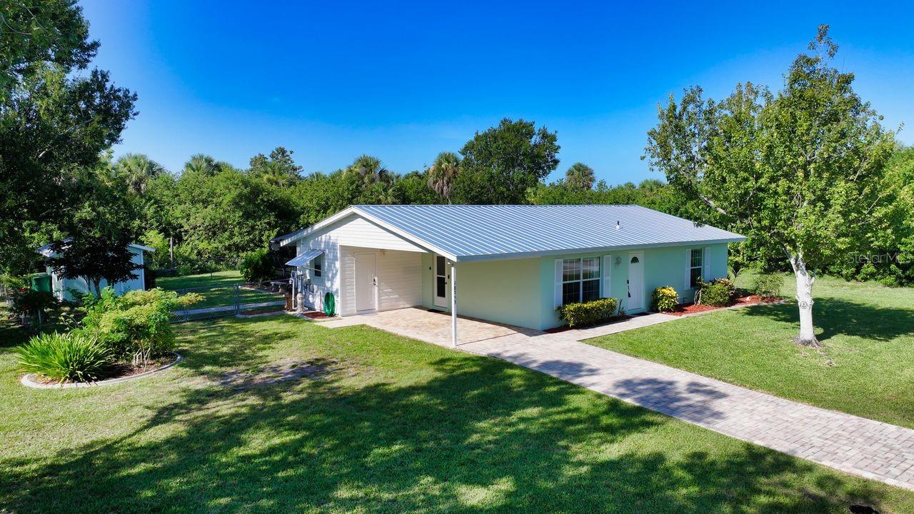 Beautiful & Charming this Immaculate, Turnkey Furnished home sits on a park like setting with almost 1/2 acre of manicured land. The sparkling 14x27 electric heated pool has relaxing jets on the long steps & tile snook swimming on the pool wall. There is Kool Decking in the pool area & custom painted scenes of life in olde Florida on the walls of the 09x35 covered lanai, which blends perfectly with the surroundings. Seller rented the home out last season for $5000 monthly. This lovely Home has been completely renovated so all of the work has been done for you. The living room has an electric fireplace that is set into the wall of stacked stone & a Roku 55" Smart TV located above the electric fireplace. Kitchen has 42" wood cabinets with crown molding; soft close drawers; tile & stacked stone backsplash; one-of-a-kind, hand picked, granite countertops/breakfast bar; pendant lighting over the breakfast bar & new stainless steel appliances. Coffee Bar area, which is 8'x9' is located between the kitchen & the separate dining room. The ceiling in the dining room & 3rd bedroom has been raised to 9'. Primary suite has Tommy Bahama style furniture & two large closets & is located at the back of the home. Primary bath has a large tiled shower, tall wood vanity & granite countertop. Guest suite is off of the living room at the front of the home & has a 42" Roku TV & the guest bath is a tub/shower combination with tall wood vanity & granite countertop. There are tile floors throughout with 5" baseboards & the Primary Bedroom & 2nd bedroom have luxury vinyl flooring. Home has a metal roof, which was done to Miami Dade standards having a screw every 6 inches & a 3rd nail on the roof trusses; 12'x22' pavered carport attached to the home has 1/2" plywood & hurricane straps; 10'x14' shed has electric & a loft; 20'x20' detached carport is on a 30'x30' asphalt pad & is located on the 2nd lot for your boat & extra vehicles. The detached carport also has outlets at the back & a sensor light on a telephone pole to light up that area. There is an outside plug for a generator. The a/c condenser, pool pump & pool heater are all elevated. The lot that the home sits on is fenced in the back yard for your four legged friends. There is a horseshoe pit on the 2nd lot & lots of space for other activities. There is a park with a playground nearby plus a boat & kayak launch. Everything in this cozy & comfortable home has been well thought out when it comes to enhancing your lifestyle in Florida.