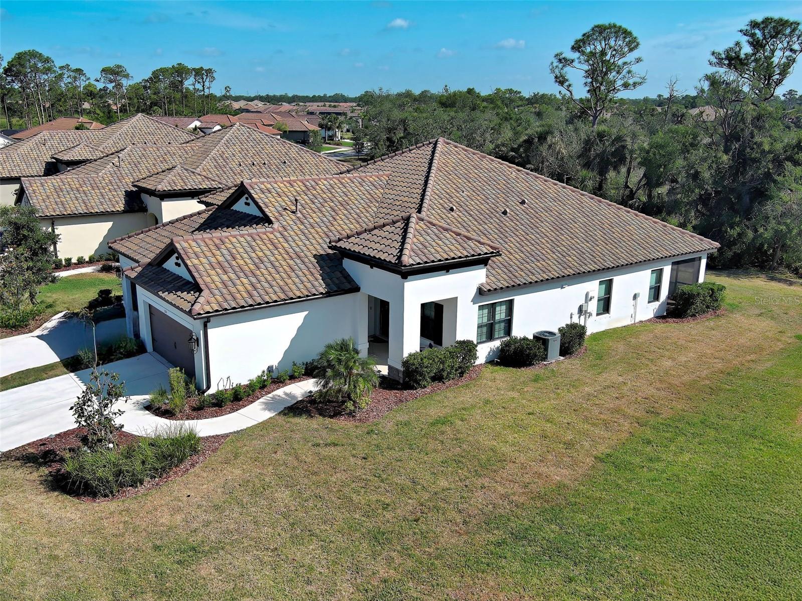 LIVING THE DREAM IN FLORIDA! This nearly new 2021-built villa with 2 BEDROOMS, 2 BATHROOMS, DEN & 2 CAR GARAGE is ideally situated in Vicenza, a gated Italian-inspired resort community designed for those who appreciate both beauty and tranquility. MOVE-IN READY & AVAILABLE NOW, there’s no need to wait for new construction. Nestled on a quiet, low-traffic street, THIS VILLA IS JUST A SHORT DISTANCE TO VICENZA’S AMENITY CENTER, INCLUDING TWO DOG PARKS, A RESORT-STYLE HEATED POOL WITH SPA & CABANAS, PICKLEBALL & BOCCE COURTS, A CLUBHOUSE, AND MILES OF TRAILS that wind through lush nature preserves. UNDERGROUND UTILITIES MEAN NO OVERHEAD POWER LINES NEAR THIS VILLA. From the moment you arrive, the expansive lawn and charming covered porch invite you to unwind and take in a breathtaking Florida sunset. Infused with a modern coastal aesthetic, this home HAS BEEN RECENTLY PAINTED and features a soothing palette of warm grays & crisp whites, complemented by designer lighting fixtures & contemporary ceiling fans. High ceilings add volume and openness, creating an airy ambiance throughout the home. Inside, large-format tile flooring flows seamlessly through the main living spaces, offering sophistication and ease of maintenance. At the front of the home, a light-filled versatile den or office space is enclosed by elegant double doors, providing both privacy and a peaceful retreat. The heart of the home is an open-concept great room, thoughtfully integrating the kitchen, dining and living areas into one cohesive space perfect for entertaining or casual everyday living. The gourmet kitchen features light gray cabinetry, quartz countertops, stainless appliances including a gas range, and a timeless subway tile backsplash set in a herringbone pattern – blending style and functionality. Large sliding glass doors flood the space with natural light and opens to the screened lanai, where you’ll enjoy serene views of the nature preserve just beyond – your private piece of paradise. THE LANAI HAS OPTIMAL NORTHEAST ORIENTATION TO MINIMIZE AFTERNOON HEAT IN THE LIVING AREAS. THE FRONT PORCH FACES SOUTHWEST WHERE ONE CAN ENJOY A BEAUTIFUL SUNSET. The spacious primary suite, tucked away at the rear of the home for privacy, is a tranquil retreat. The en-suite bathroom is spa-inspired, complete with a luxurious walk-in shower, and separate vanities. The split floor plan offers privacy for guests, with a guest bedroom and full bathroom located at the front of the home. Vicenza is a vibrant, active-lifestyle community with regular social events. Residents enjoy LOW HOA FEES and NO CDD FEES. You’re going to love Vicenza’s convenient location to the Gulf Coast beaches, Venice Myakka River Park, Historic Downtown Venice, Sarasota Memorial Hospital, Atlanta Braves CoolToday Stadium, I75, golfing, boating, fishing, waterfront dining, fine dining, shopping, nightlife & more! This villa offers more than just a home, it’s a lifestyle waiting to be embraced! Don’t wait – schedule a showing today & be sure to ask about the home warranty sellers are including!