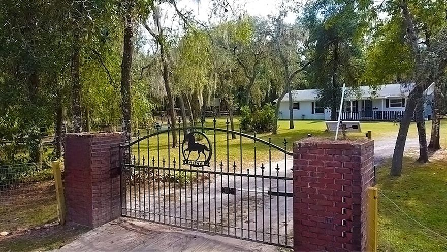 Discover the joy of country in this charming 3-bedroom, 2-bath farmhouse nestled on 2.6 acres of pure natural beauty. As you step onto this property, you'll be greeted by the inviting embrace of a fully fenced landscape, complete with two electronic entry gates, ensuring your privacy and safety. The vast night sky, adorned with bright stars and moonlight, bathes the surroundings in a magical atmosphere that simply cannot be replicated. 

Inside, the farmhouse opens up to reveal a welcoming and open floor plan. Picture cozy evenings by the wood-burning fireplace in the living room, and an additional Florida room that beckons you to relax and unwind. This home has been thoughtfully updated with newer paint, appliances, roof, windows, and beautifully renovated bathrooms.

But there's more to this country haven than meets the eye. For the hobbyist or DIY enthusiast, there's a pole barn, two sheds (one with electricity, AC and a finished interior - perfect for a man cave, she shed or office), and a pavilion hangout area with a slab floor. There's also a small horse stable and a separate fenced-in area, ideal for your beloved farm animals. This property caters to your every need.

The split floor plan offers the convenience of indoor laundry, making everyday chores a breeze. In this peaceful neighborhood, you'll find wonderful neighbors and fertile soil, making it a prime location for farming enthusiasts. Quick access to I-75 is just a 4-minute drive away, ensuring you're well-connected to nearby towns.

When it's time for shopping, you're in luck. Besides Downtown Dade City, Brooksville, and Bushnell, all just a short drive away, providing easy access to all your shopping needs, you'll find the convenience of Winn Dixie/Aldi's located just 2.5 miles away. Yet, the country charm remains untouched, offering a quiet and serene lifestyle within reach of modern conveniences.

For nature enthusiasts, the Withlacoochee State Park is a mere 4 minutes away, offering endless opportunities for outdoor adventure. The Withlacoochee State Trail, along with various trailheads, is also just minutes from your doorstep. And if you're an ATV enthusiast, you'll love being only 8 minutes away from the Croom ATV trails.

Embrace the joys of farm living with fresh eggs, happy animals, and the opportunity to cultivate a flourishing garden. With multiple farmers' markets nearby and a delightful Mexican restaurant just a mile away, you'll have everything you need to savor the delightful rural life. This is your chance to make this nature lover's paradise your very own. Don't miss out on this extraordinary opportunity!