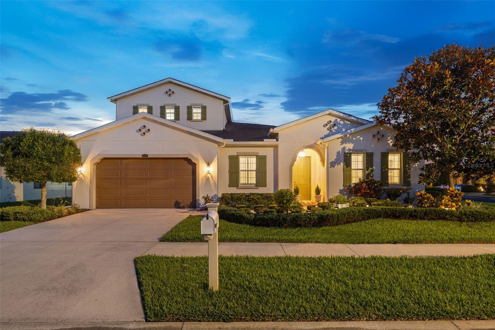 Located in the gated community of Meadow Pointe, this home invites you to step inside and experience a thoughtfully crafted vision of higher-level living. The moment you enter, the ambiance is set with striking archway entries and 12-foot ceilings, which are further exasperated by the long, dramatic entry and hallway, creating an immediate sense of grandeur. These elements are complemented by tray ceilings and recessed lighting that guide you through the home with intention and elegance. As you move deeper into the space, the attention to detail becomes even more apparent. The adjustable louvered shutters used for interior window treatments not only add functional charm but also showcase a custom aesthetic. This is further elevated by accent trim and paneling on both ceilings and walls, which tastefully combine for a timeless look, one that subtly portrays wealth while evoking a lasting sense of luxury. The home’s design centers around an open entertainment space, encouraging connection and flow, while the split floor plan offers a thoughtful layout for those who seek privacy when needed. This seamless balance between gathering and retreat is one of the home’s most appealing qualities.
Leading into the expansive primary retreat, the sense of refinement continues. Showcasing its prominence with high vaulted tray ceilings, the primary suite is purposely set apart from the rest of the home. A private hallway, flanked by dual walk-in closets ushers you into a spa-like en-suite bathroom that defines elegance. Here, a large soaking tub and expansive walk-in shower cove create a setting that feels like a personal sanctuary. Transitioning from private to public, the home’s spacious living room, anchored by an oversized kitchen island, seamlessly connects with the kitchen and eat-in dining space, making it the ideal environment for hosting. Bathed in warmth from an abundance of natural light, this space naturally becomes the heart of the home, a place of conversation, laughter, and memories. Surrounding this central hub are three additional bedrooms, a designated office/music room, laundry room and a formal dining room. Each room designed to feel tucked away for privacy while still being intimately connected. These rooms function like arteries to the heart, circulating purpose and livability throughout the home. While upstairs, the secondary suite (5th bedroom) continues the theme of flexible, intentional design. Complete with its own en-suite bathroom and sizable closets, it offers an excellent solution for extended-stay family, guests, or those in need of a retreat. Alternatively, the space offers endless possibilities; whether you envision a movie theatre, game room, art studio, or something uniquely your own. Adding to this already exceptional offering is the convenience and promise of growth just beyond your doorstep. The soon to be developed 30+ acre Legacy at Wiregrass Ranch will serve as Wesley Chapel’s new gathering and downtown district. Featuring retail, dining, office, and residential offerings. Combined with the new Orlando Health hospital opening in 2026, the future here is bright. As Wesley Chapel continues its transformation, it is quickly rising as Greater Tampa Bay’s premier destination for those seeking a luxury lifestyle by design.