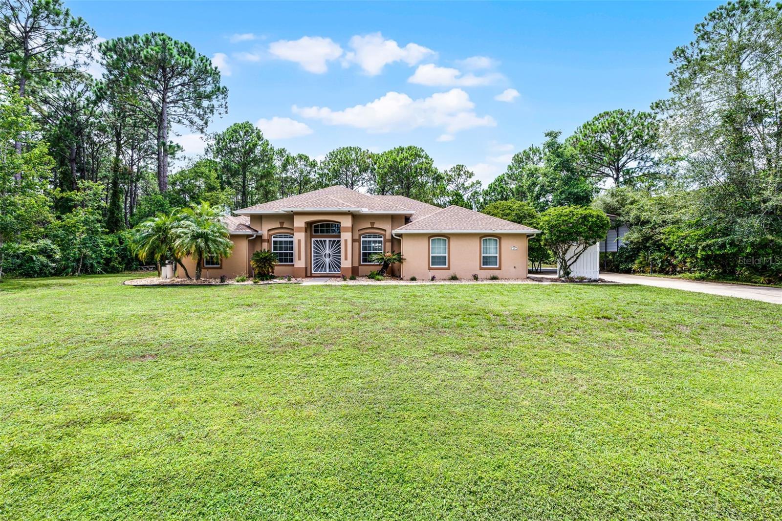Under contract-accepting backup offers. One or more photo(s) has been virtually staged. Spacious Pool Home on a private, 1 Acre Lot! Nestled in a serene setting with no rear neighbors, this beautiful 4-bedroom, 2-bath home offers the perfect blend of comfort, privacy, and Florida living. The inviting front entry welcomes you with mature landscaping and a stylish double-door design. Inside, you'll find an open, flowing layout that is filled with natural light and designed for both relaxed living and stylish entertaining. The owner’s suite features a generously sized bedroom, walk-in closet, and a spa-inspired bath complete with a soaking tub, separate walk-in shower, and dual vanities — the perfect place to unwind after a long day. The kitchen flows into the living areas and overlooks the screened-in pool, perfect for year-round enjoyment. Step outside to your private backyard oasis featuring a sparkling pool, expansive deck, and plenty of green space for pets, play, or gardening. An extra-long driveway leads to a covered RV or boat parking area, plus there’s an additional storage shed for all your outdoor gear. Situated on an acre lot and surrounded by lush greenery, you’ll enjoy peace and seclusion while still being just minutes from shopping, dining, and major highways. Don’t miss your chance to own this rare find — a pool home with room to spread out, park your toys, and enjoy the Florida lifestyle! Home is on .53 acres. Additional parcel (80-31-01-14-0010) is included in the sale for a total of 1.06 acres.