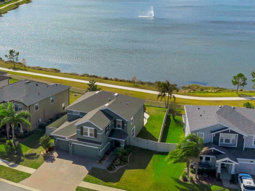 ***New 5 Ton AC installed Feb 2026***
Welcome to a home that truly feels like a permanent vacation. Perfectly positioned with breathtaking waterfront views, this impeccably maintained residence delivers the Florida lifestyle buyers dream about—peaceful, scenic, and effortlessly elegant.

Located in the highly sought-after Long Lake Ranch, this vibrant community offers resort-style pools, a community dock, miles of scenic trails, and a neighbor-friendly atmosphere. Convenience is unmatched with quick access to the Suncoast Parkway, Publix, GreenWise, Starbucks, Panera, dining, shopping, Tampa, outlet mall, medical facilities, pet services, and more.

From the moment you arrive, the home’s curb appeal makes a statement. Upgraded landscaping with concrete edging and a fully fenced yard with dual side gates create both beauty and functionality.

Inside, a thoughtfully designed semi–great room floorplan welcomes you with an inviting entry and formal dining room featuring elegant tray ceiling detail. Upgraded wood shutters throughout add warmth and timeless style. The heart of the home is the stunning kitchen—complete with granite countertops, staggered white cabinetry, stainless steel appliances, subway tile backsplash, upgraded hardware, a large working island, and an oversized walk-in pantry.

A first-floor, possible, in-law suite with guest bath offers flexibility for visitors or multi-generational living. Upstairs, retreat to the private primary suite with tranquil water views, spa-inspired bath, frameless glass shower with rain and handheld heads, dual vanities, and a luxurious soaking tub. A second-floor laundry room adds everyday convenience, along with three additional bedrooms, a full bath, and a spacious bonus room ideal for a media room, game room, home office, or creative space.

Car enthusiasts and hobbyists—this garage is a dream. Featuring added A/C, attic solar exhaust fan, 20-amp electrical service, abundant outlets, and overhead storage shelving, it’s designed to impress.

Step outside to your personal oasis. The expansive rear lanai overlooks the water and sets the stage for unforgettable entertaining. The upgraded saltwater heated pool and spa offers something for everyone—sun shelf for lounging, spa for unwinding, and a decorative rock waterfall leading into an 8-foot deep pool, perfect for swimming or play. Lush, resort-style landscaping completes this serene backdrop.

This home is the total package—location, lifestyle, upgrades, and views rarely found together.
Schedule your private showing today and experience why this is truly a must-see Florida retreat.