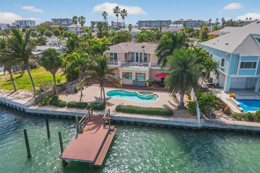 Waterfront Paradise with Gulf Access & Designer Potential in Madeira Beach. Discover the ultimate boating lifestyle and coastal convenience at this spacious, two-story waterfront home in Madeira Beach. Just blocks from the white sands of the Gulf (with beach access at popular Caddy’s), this property is perfectly situated on a protected wide water basin, offering easy and direct boating access through the Intracoastal Waterway and John’s Pass. This 4-bedroom plus a bonus room, 3-bath residence offers 2,380 sq ft of living space on a 63 x 115’ lot. It’s an ideal setting for those who appreciate the water view and outdoor living, featuring a salt water pool and spa with paver decking, an outdoor shower, and a private dock with tie poles, electricity, and water. Enjoy spectacular views from the second-story balcony with a spiral staircase to the pool area. A Value-Add Opportunity: The home presents a unique opportunity to customize the first floor core living spaces to match your exact vision. The property experienced flooding from 2024 hurricanes and has been remediated, leaving the kitchen and downstairs bedrooms as a blank canvas. Major Systems Replaced: Seawall (2020), Windows/doors (2021-2023), Both A/C units & pool pump equipment (2025), Water heater (2025), Flat roof (2025). Enjoy nearby grocery stores, drugstores, and a variety of restaurants and services, all within minutes. With no homeowner’s association and surrounded by new million-dollar-plus homes being built and elevated, this is a prime location to consider. The location, water access, and opportunity for immediate customization make this a must-see property for someone looking to customize their own piece of paradise without the hassle of new construction. Make an appointment to see it for yourself today!