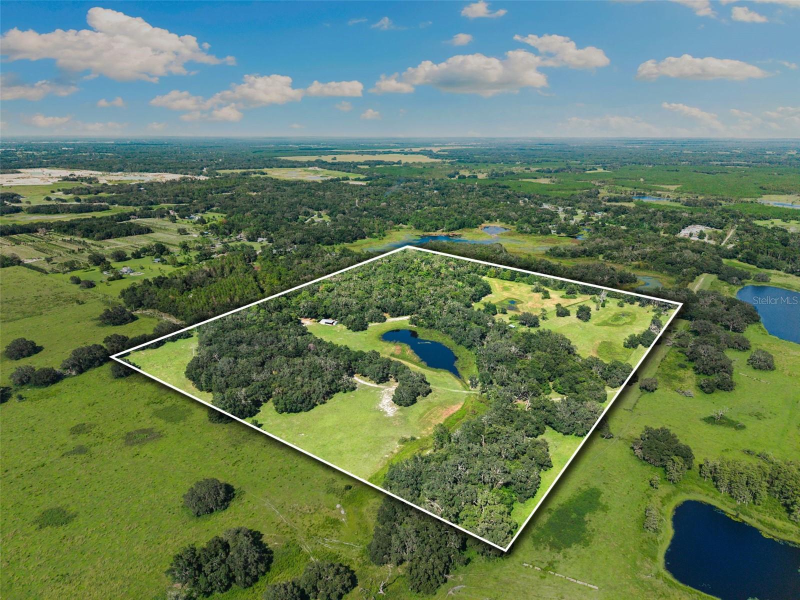 Discover a once-in-a-lifetime opportunity to own 50 ACRES in Spring Hill, just a few miles north of 52. As you arrive, canopy trees line your picture-perfect drive, welcoming you into a peaceful sanctuary. AC ZONING allows for farming and multiple INCOME PRODUCING OPPORTUNITIES — RARE FIND! The 2015 single-family residence has been tastefully upgraded with fresh paint, new flooring, and decorative wooden beams throughout. From the screened front porch, enjoy serene views of your private pond—an ideal spot to sip your morning coffee while listening to the quiet hum of nature. Inside, soaring ceilings, abundant natural light, and PANORAMIC VIEWS create a warm and inviting atmosphere. The kitchen features stainless steel appliances, crisp white cabinetry, a walk-in pantry, and granite countertops, all overlooking the living room—perfect for entertaining. Additional upgrades include a reverse osmosis system and tankless water heater for comfort and peace of mind. The primary suite offers generous space, beautiful views, and a luxurious shower with decorative tile. Behind newly added barn doors, you’ll find a flexible room—ideal as an office, bonus space, or additional bedroom. The third bedroom includes a spacious walk-in closet and overlooks the treed backyard, while the second bathroom has been updated with a new vanity and decorative tile. THE LAND IS TRULY ONE OF A KIND. With open pastures, it’s ready for horses, cattle, or any vision you imagine. An enclosed workshop with garage space, along with a large pole barn overhang, provides ample room for equipment, storage, and hobbies. The property’s perimeter is fully fenced, offering both security and functionality, and a built-in trail system allows for horseback riding along the boundaries of the property. Whether you’re dreaming of a FAMILY COMPOUND OR PRIVATE RETREAT, this property provides ENDLESS POSSIBILITIES. Nestled in with NO HOA, you’ll enjoy COMPLETE PRIVACY while remaining just minutes from grocery stores and a short drive to Tampa. This is a property that must be experienced in person to truly appreciate its beauty and potential.
Be sure to watch the property short film: https://properties.premiermediag.com/videos/0198dc88-d1e7-73b7-94a4-7ee61a0a8f10
Don’t miss out—schedule your private showing today!