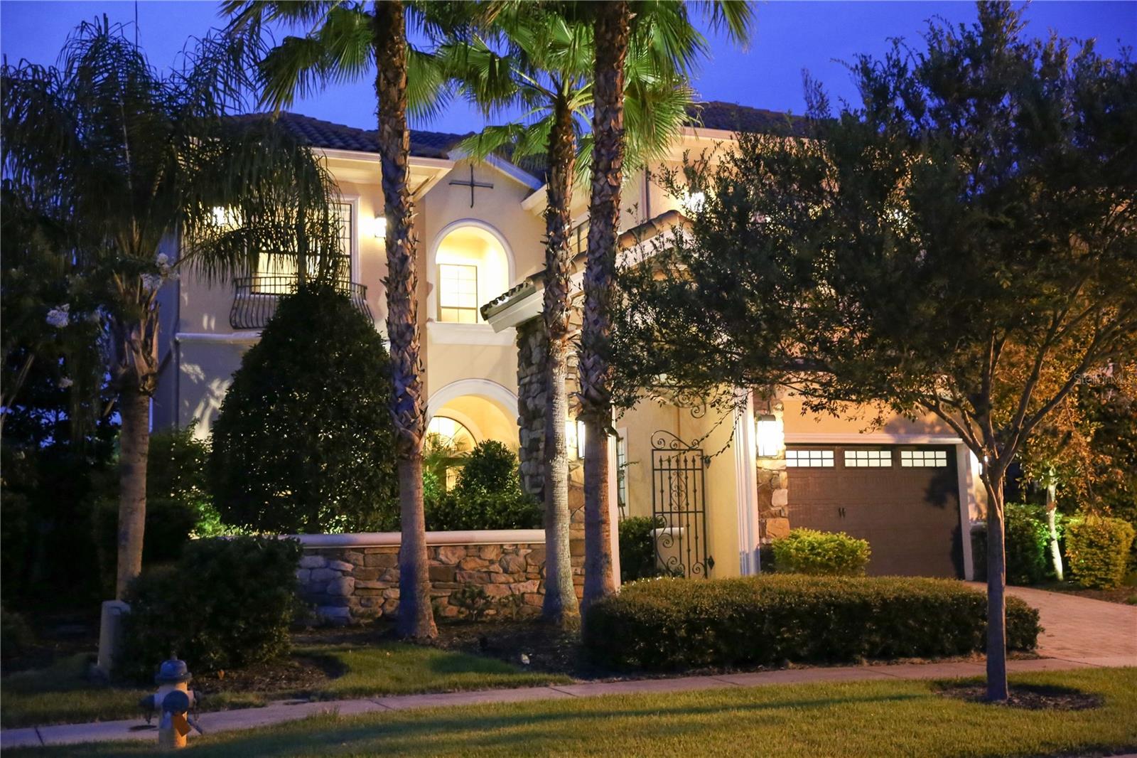 From the moment you step through the front gate and into the private courtyard , you will understand why this lovely villa is named Villa of Joy. Luxury living awaits you. This home is one of the most delightful and contemporary homes in this exclusive Community. While each room is impeccably designed, the villa maintains an environment of tranquility and relaxation. The home features 5 spacious bedrooms , all with ensuite bathrooms. The master bedroom , and two further bedrooms are located upstairs, while two bedrooms are downstairs. There are three unique living areas , perfect for families that need a lot of space.The formal living room features a built in fireplace, cathedral ceilings and modern styling surrounded with natural light from the wall of french doors. The gourmet kitchen, fully fitted with stainless steel appliances has two dining areas. The outdoor amenities will not disappoint. The pool area is paved , and boasts a summer kitchen with bbq, sink and refrigerator . From the rear of the property, either from the pool deck or viewing from the large tiled balconies above, you can enjoy a panoramic view of natural woodland and the golf course. Reunion Resort offers its own array of entertainment, amenities and restaurants and is also conveniently located minutes drive from the many other famous Orlando attractions such as Disney, Universal Studios and Sea World.