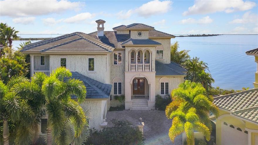 Wow, wow, wow…. Get ready to see one of the most incredible homes on the water you’ll ever lay your eyes on.   This home is unequaled in its magnificent positioning on the tip of the peninsula and gives you a nearly 360 degree view of the entire Tampa Bay.  See Downtown Tampa in all its glory from your pool while smelling the salt in the air.  Magnificent stone columns great you at the entrance, you will fall in love with the regal estate immediately.  The description does not do this home justice with its rich woodworking, remarkable lighting, graceful faux finishes, elegant archways and fine travertine marble; complemented by ingenious floor plan that maximizes views of the water.  Impressive living room, office, wine room and den are finished with the most exquisite of materials.  Astonishing gourmet kitchen w/ SubZero, Thermador & Bosch appliances, rare custom cabinetry, & splendid, contoured ceilings is an absolute dream. Wake up in a master bedroom with views of Tampa Bay that are simply incomparable.  The master boasts a huge sitting area, a stunning bath and shower that brings in plenty of light.  After waking up in luxury walk just a few steps to your very own full-size fitness room.  Each suite includes a private balcony and luxury bath offering the privacy and elegance to your guests as well as yourself.  How about waking up early and getting directly on the water from your own high and dry doc.  Boat downtown for the next Super Bowl or Lightning Championship.  Expansive 3 car garage that you can fit three cars in and have enough space for storage and hobbies.  Never-ending, breathtaking panoramic water view makes the Pirates Cove office space the perfect place for your next novel or just watching the fish swim by.  Built to last, with the most current/strong building techniques the plans are available for any future site development.  This home has charm and the traditional Florida feel that makes this a Home but be ready to be amazed how grandiose that can be.