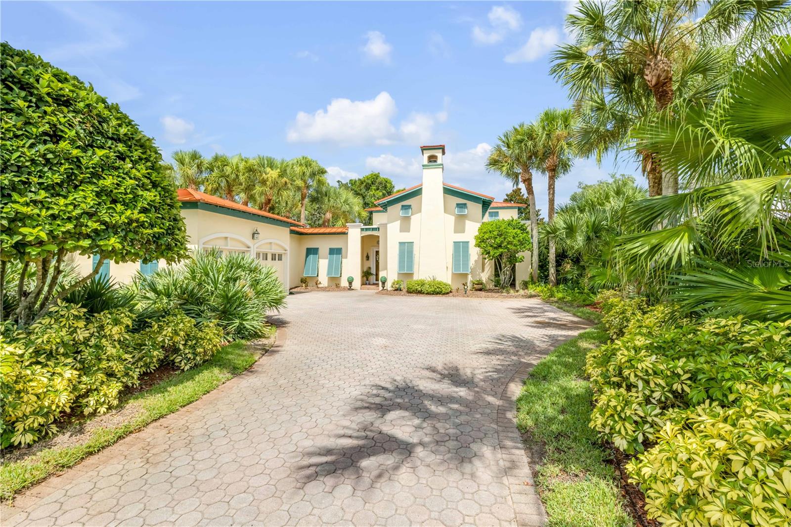 Prepare to be wowed by this stunning 3 bedroom, 3 1/2 bath, Spanish inspired residence that exudes charm, warmth and casual elegance. Upon entering you are drawn to the large living area with vaulted ceilings, rich Mexican tile, a fireplace and charming clerestory windows inspired by Spanish hacienda design that allow for soft natural light. The thoughtfully designed layout includes a ground-floor primary suite for comfort and privacy, while each additional bedroom offers its own en-suite bathroom and French doors onto Juliet balconies. At the heart of the home is an expansive open-air/Lanai enclosed by a solid roof and walls, yet open to the breeze through large, screened windows. The home surrounds an open courtyard with lush landscaping and a beautiful Spanish-style fountain. Room for all of your toys in the extra deep 2 car plus golf cart garage. New metal roof, fenced yard, new LVP in bedrooms. This home offers a rare blend of style and serenity. A must see.