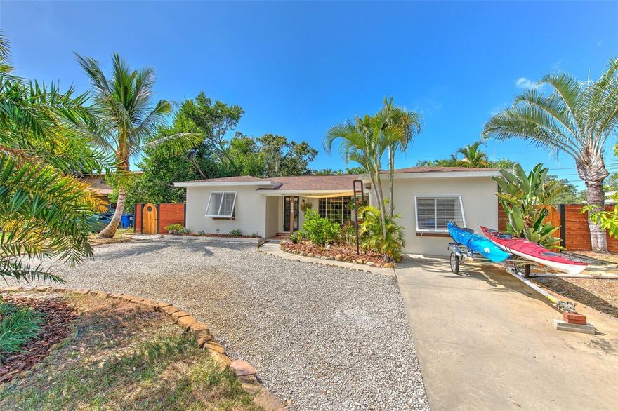 One or more photo(s) has been virtually staged. Welcome to this St. Pete outdoor oasis with a dream interior layout where the spacious open concept kitchen with a newer oven, oversized primary suite with updated walk-in closet built-ins, and sun-filled dining room all offer views of the pool, patio, palm and fruit trees, and the sunset. Upon entering from the circular driveway and covered front porch, you'll arrive into the great room and to your left, you'll find the secondary bedrooms and bathroom. In the rear of the home, the primary suite is large enough to comfortably accommodate a sitting room as well as a king sized bed, and has recently had a 1970s bathtub removed from the room to maximize space. In the front of the home, a bonus room is privately situated, perfect for a home office, pool table, playroom, or a fourth bedroom. Entering the backyard oasis through French doors, you'll find a saltwater pool with a newer salt cell, fully fenced yard with beautiful custom side gates, covered deck, fire pit area, rain barrel, and storage shed. For peace of mind, the roof age is 2021, AC is 2019, pool pump is 2023, located in an X flood zone, and the home features new soffit and gutters. For fun and even more fresh air, the Pinellas Trail is located about 3 blocks East and the Jungle Prada Park and Boat Ramp are located about 1 mile West. And even though this private backyard offers stunning sunset views, the Pinellas beaches are also nearby!
