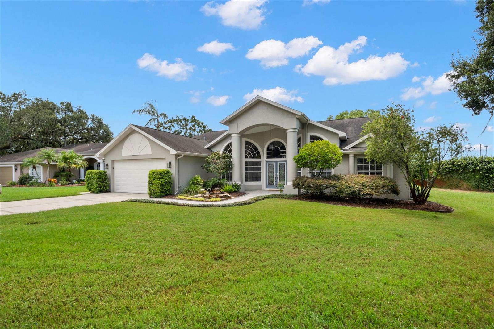 This spacious 4-bedroom, 2-bath, 2-car garage pool home is tucked away in the sought-after Cranes Roost community, just minutes from vibrant downtown New Port Richey. Offering the perfect balance of privacy and convenience, this home has been thoughtfully updated and meticulously maintained so you can move right in with peace of mind. Step through the tall entryway into an open & light-filled Great Room that includes a formal dining area with oversized windows and patio doors. The custom kitchen is a chef’s dream with solid wood cabinetry, granite countertops, stacked dual ovens, cooktop, stainless steel appliances, and a cozy breakfast nook overlooking the pool. The oversized primary suite boasts lanai access, a walk-in closet, and a spa-like ensuite with dual sinks, soaking tub, and separate shower. Three additional bedrooms and 1 bathroom provide plenty of space for family or guests. Outside, enjoy Florida living at its finest with a screened-in pool, and spacious pavered patio —perfect for entertaining. Major Updates Include: New carpet (2024), Exterior paint (2021), Pool resurfaced with Diamond Brite (2021), new pavers installed at pool & entry (2021), Irrigation pump replaced (2021), Water heater (2021), AC (2017), Pool pump (2017), Roof (2011), Primary bath remodel (2011), Custom kitchen (2015) and much more. With all the big-ticket items already done, this home is truly move-in ready. Conveniently located near shopping, dining, and major roadways.