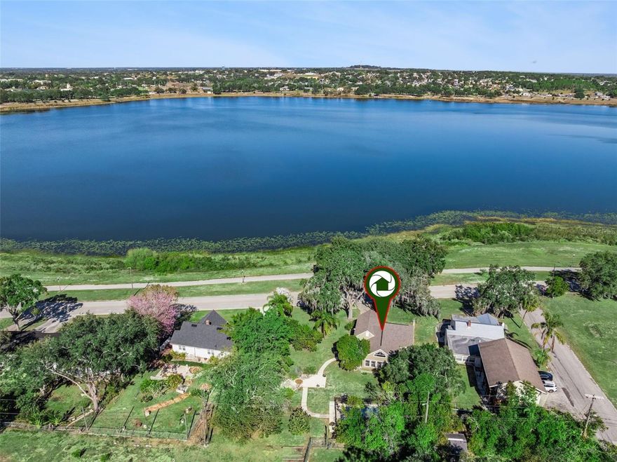 Located on a picturesque, tree-lined street in the heart of Lake Wales, this enchanting waterfront-view 3-bedroom, 2.5-bath cottage blends timeless charm with modern comfort. Situated on a premium double lot, the property offers exceptional privacy—whether relaxing on the open patio or enjoying the swimming pool.

Upon entry, you’re welcomed by original hardwood flooring that immediately showcases the character of this vintage cottage. The spacious living room features lovely lake views and a cozy wood-burning fireplace accented with a marble tile surround, creating a warm and inviting atmosphere.

The remodeled kitchen is thoughtfully designed with custom cabinetry trimmed in crown molding, a glass tile backsplash, granite countertops, recessed lighting, and a stainless steel appliance package—including a double-oven range. A bronze gooseneck faucet and double-basin composite sink add both style and function. The formal dining room is conveniently located nearby, making entertaining effortless.

The generously sized primary bedroom suite offers direct patio access, vaulted ceilings, tile flooring, a walk-in closet, and an en-suite bathroom. The updated bath features a charming vintage-style pedestal sink and a walk-in tiled shower.

Throughout the home, you’ll find delightful vintage details, including a second-floor landing adorned with a twisted iron railing, cedar closets, 6" baseboards, and a built-in bureau in one of the guest bedrooms.

Outdoor living truly shines with multiple spaces to enjoy, including two open patios and a resurfaced in-ground pool—perfect for warm summer evenings. Additional features include: One-car garage with half bath, Architectural shingle roof (2021), Double-pane windows, Hardie board siding, Driveway with off-street parking

The property is located just steps from the shores of Lake Wailes, offering a scenic walking trail, boat ramp, fishing pier, and picnic pavilion. Enjoy the convenience of nearby historic downtown Lake Wales, where brick-lined streets lead to quaint shops, charming boutiques, inviting cafés, and the awe-inspiring Bok Tower Gardens.

This truly special cottage offers a rare opportunity to enjoy vintage charm, modern updates, and an exceptional lakeside lifestyle.