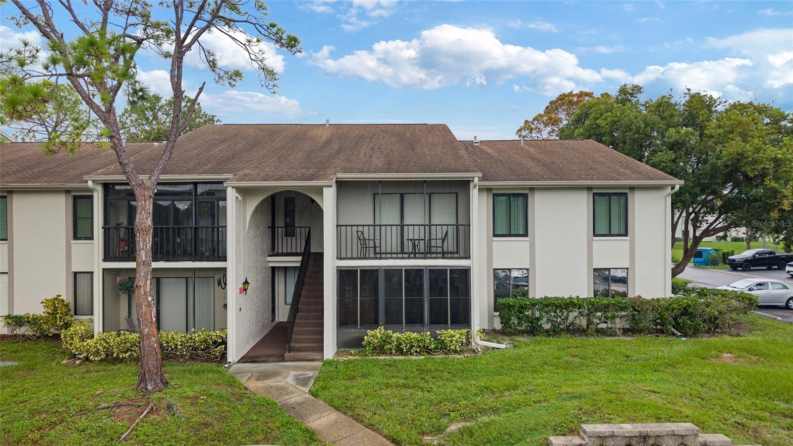 One or more photo(s) has been virtually staged. Welcome to this beautifully updated 2-bedroom, 2-bathroom ground-floor end unit in the highly sought-after 55+ community of Pine Ridge at Palm Harbor. This move-in-ready condo has been thoughtfully upgraded from top to bottom for peace of mind and comfortable living. This first floor condominium offers a spacious floor plan featuring a bright living area that opens to the private screened in porch. Recent updates include: a new electrical panel, updated plumbing, fresh interior and exterior paint, new carpet, new fans, new lighting, and new hardware throughout. The kitchen features stunning granite countertops, 2023 stainless steel appliances, a pass thru window to the dining room, an eat in breakfast nook, and plenty of cabinet space. The master bedroom boasts a en-suite bathroom with a glass shower door and walk in closet. The second bedroom provides accommodations for guests. Both bathrooms have been refreshed, including a new vanity in the hallway bath. You will love the convenience of an indoor laundry room with plenty of space. New water heater 2023.The HVAC was replaced in 2018, and the roof was replaced in 2022. Enjoy your morning coffee or evening wine on the private screened-in lanai overlooking green space. Additional highlights include in-unit laundry, spacious closets, and assigned parking just steps away. Pine Ridge offers fantastic amenities including a heated community pool, shuffleboard courts, walking paths, and a welcoming clubhouse. Located just minutes from shopping, dining, golf courses, and Florida’s world-famous Gulf beaches, this condo is the perfect blend of comfort, convenience, and community. Schedule your private showing today and discover why so many love calling Pine Ridge home!