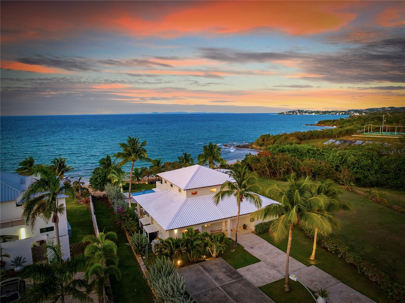 Step into unparalleled beachfront living on Vieques’ serene Atlantic shore at Wander Villa, nestled within the private, gated Martineau Beach Estates. The villa is perched gracefully above its own protected stretch of golden sand, offering unobstructed views of the sea, nearby islands like Culebra and St. Thomas, and breathtaking sunrises and sunsets. An infinity-edge pool appears to merge with the ocean horizon, while a well-appointed entertainment pavilion and outdoor kitchen invite seamless indoor outdoor gatherings.
Designed with tropical elegance and laid-back luxury in mind. The interiors blend coralina and wood textures with open-concept living spaces, vaulted ceilings, marble and travertine flooring, and wall-to-wall windows to bring the natural beauty in Three generous bedroom suites all feature spa-inspired en-suite baths, walk-in closets, and private balconies—each capturing ocean breezes and panoramic views. The entire second-floor primary suite stretches the full width of the home and boasts a sweeping balcony with uninterrupted Atlantic vistas.
Outside, every detail enhances the island experience: multiple lounge areas, outdoor dining under a gazebo, an outdoor shower, and lush tropical landscaping creates a resort-like ambiance. With high-end amenities including zoned mini-split cooling, a wet bar, and covered carport parking, the villa reflects refined comfort paired with Vieques’ relaxed spirit. Whether you're seeking an upscale retreat, investment opportunity, or a canvas for island events, this property delivers exclusivity, privacy, and a true connection to nature.