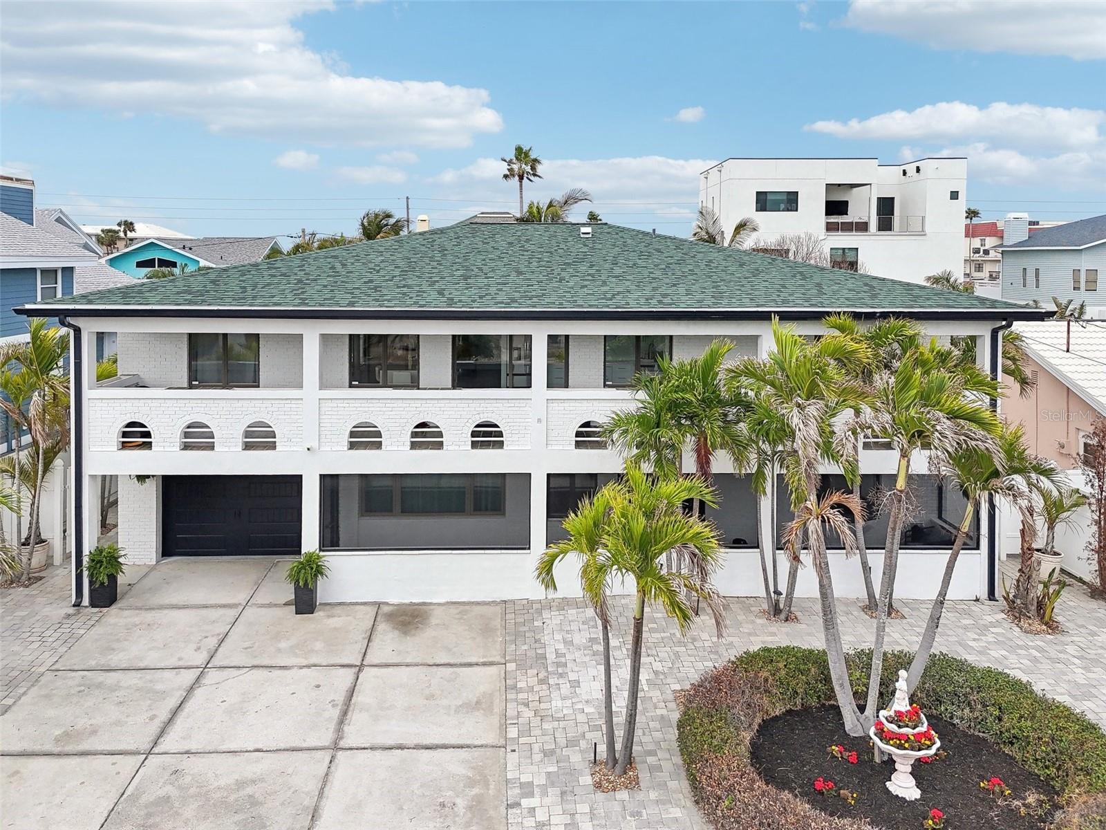 Welcome to the Shores of Belleair Beach, just steps from the Gulf, where this beautifully updated 2-story beach home awaits its new owners. Featuring nearly 3,000 square feet of versatile living space, this charming residence greets you with a welcoming, low-maintenance pavered front yard. The ground floor has been thoughtfully converted into additional living space, offering two non-conforming bedrooms, a cozy living room, and an area perfectly suited for a second kitchen—making it ideal for an in-law suite. Additionally, a private chef’s kitchen at the rear provides ample storage, further enhancing the endless potential this unique property holds. Ascend to the main living area on the second floor, where no expense has been spared in recent renovations completed in 2024. The living room, centered around a warm wood-burning fireplace, flows seamlessly into the elegant kitchen. Here, you'll find beautiful quartz countertops, high-end Café stainless steel appliances, a commercial vent hood, and a convenient butler’s pantry offering extra storage. A large central island with generous seating and a built-in wine refrigerator creates the perfect space for entertaining. On this upper level, three well-appointed bedrooms are arranged in a desirable split floorplan, complemented by two stylishly renovated bathrooms featuring seamless glass doors and modern LED lighting. Enjoy picturesque sunrises from your expansive 53-foot easterly balcony, and savor stunning sunsets from the 23-foot westerly balcony. Outside, the spacious fully pavered backyard is perfect for gatherings, featuring charming pergolas, lush palm trees, and a well-equipped outdoor kitchen for alfresco dining. Added peace of mind comes from a new roof installed in 2023, ensuring worry-free living for years to come. Located in the charming Belleair Beach community with no HOA fees, residents enjoy exclusive amenities including private beach access, tennis and basketball courts, playgrounds, parks, a marina, boat ramp, and fantastic intracoastal fishing opportunities. Just a short drive from renowned Clearwater Beach, world-class dining, and lively local attractions, this home truly captures the essence of relaxed coastal living.