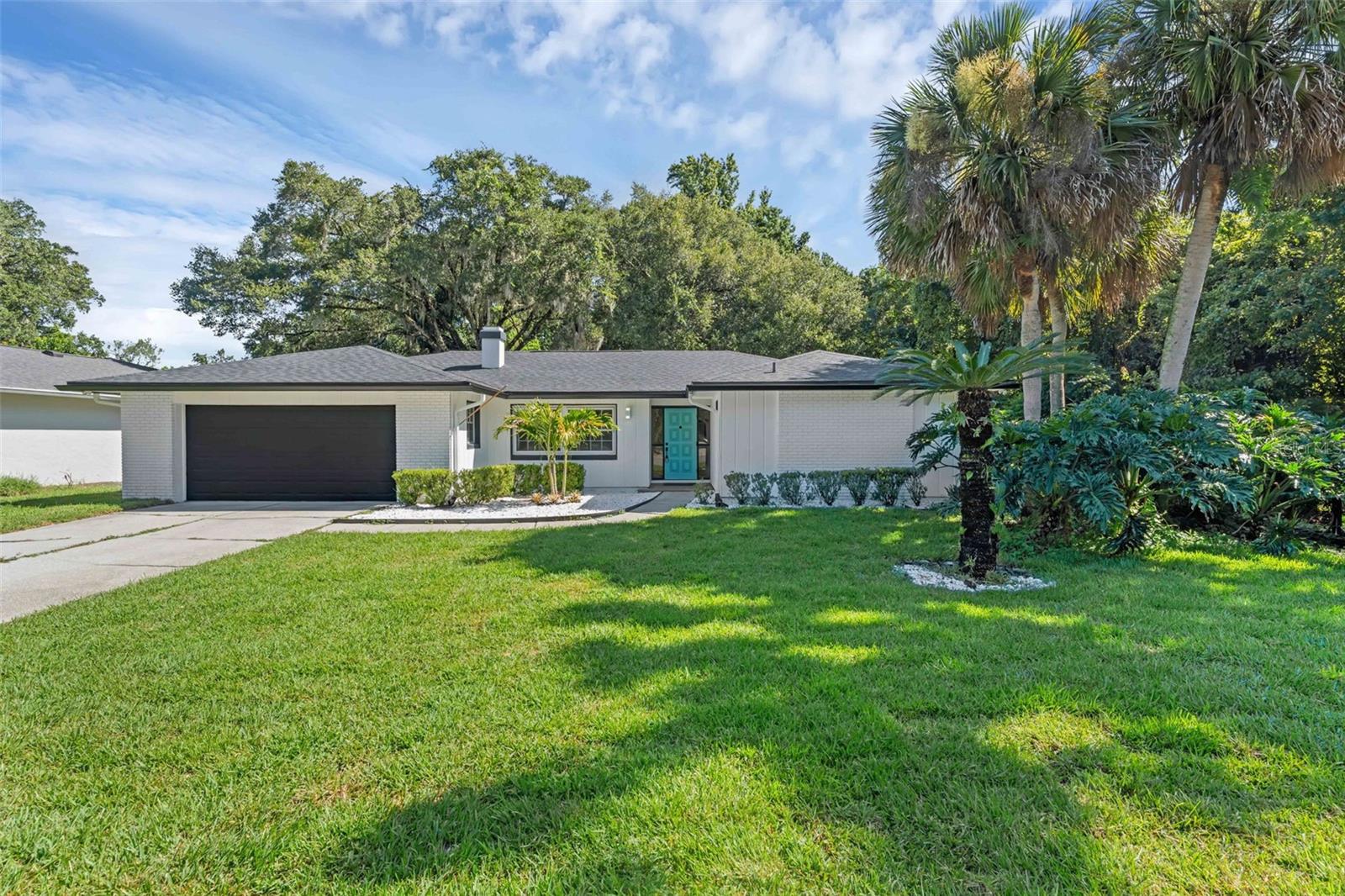 One or more photo(s) has been virtually staged. Welcome to 1054 Winter Springs Boulevard, a stunning, fully renovated residence situated on a prime, very secluded corner lot of nearly half an acre in the heart of Seminole County. With no rear neighbors and no neighbors to the right side when facing the front of the property, this home offers exceptional privacy. This unique property backs onto a serene green belt, providing a peaceful backdrop for your daily life. In the backyard, you’ll find mature citrus trees, pineapple plants, and lush landscaping, creating your own slice of Florida paradise. At the heart of the home is an oversized versatile enclosed Florida room — over 400 square feet — complete with tile flooring, a mini-split system for year-round comfort, and two ceiling fans. It’s the perfect space for hosting gatherings with family and friends. This home has been renovated from the ground up, featuring a brand NEW ROOF and AC, fresh interior and exterior paint, crown molding, recessed lighting throughout, UVB laminate flooring in living areas, and tile flooring in both bathrooms. The entire kitchen is brand new, boasting all new stainless steel appliances, new cabinets, quartz countertops, and a designer backsplash — truly a chef’s dream. All bedrooms come with custom built-in closets, providing both style and functionality. The bathrooms have been completely remodeled with dual vanities and modern LED mirrors with integrated LED lighting — perfect for sharing, whether in the primary suite with your partner or in the guest bathroom. Additional upgrades include a new sprinkler system for easy lawn care and a cozy wood-burning fireplace in the dining room. The home’s split, open floor plan offers both privacy and flow, making it ideal for modern living. Located in the top-rated Seminole County school district, this property is perfect for families seeking a quiet, established neighborhood with no HOA. Enjoy close proximity to Central Florida attractions, Orlando, major highways, shopping, dining, parks, and more. Whether you’re heading to the beaches, exploring theme parks, or simply enjoying the charm of Winter Springs, everything is within reach. This home blends modern upgrades with a spacious, private setting — a rare find in such a desirable location. Schedule your showing today!