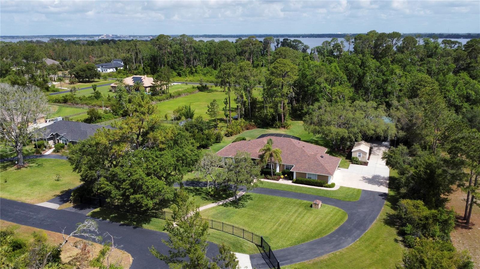 Welcome to your dream retreat in the highly desired Old Mill Run community of Tavares—this stunning custom-built 4-bedroom, 3-bathroom pool home sits on a beautifully landscaped one-acre lot, offering the perfect blend of luxury, comfort, and privacy. Designed with a spacious open and split floor plan, this immaculate home features a large kitchen with upgraded counters and appliances, upgraded porcelain tile flooring throughout, a brand-new roof with solar-powered attic fans, freshly painted exterior, new gutters, new pool screens, and a generously extended circular driveway. The outdoor space is truly exceptional and unique, with a large 36x48 pole barn equipped with 30 amp service that can easily be enclosed if desired, and an insulated workshop with full power—ideal for hobbies, storage, or even a business setup. The gated property, which borders a 30 acre farm, includes a solar-powered remote gate, providing peace of mind and seclusion in your own private sanctuary. Just ten minutes from the charming towns of Mt. Dora and Tavares, and only a fifteen minute commute to the 429, you’ll enjoy the serenity of country living while staying close to everything. For those seeking even more space, the sellers are offering the adjacent 1 ACRE parcel (MLS # O6269356) as part of a package deal with the right offer, combine both properties and enjoy your very own 2 ACRE Estate! We challenge you to find another home this meticulously maintained—don’t miss the opportunity to make it yours.