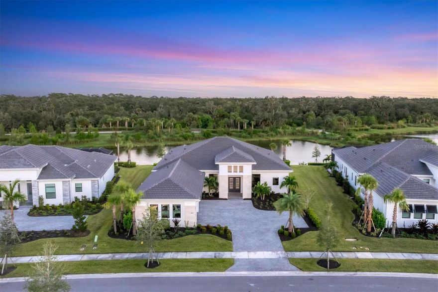 Welcome to Artistry–Sarasota, where you can experience luxurious resort-style amenities, security and maintenance-free living without the CDD fees! This beautifully designed Palmer model with bonus room and 4-bay garage provides storm security with impact windows and doors, concrete block construction and concrete tile roof, as well as the energy efficiency of spray foam insulation. With one of the most optimal floor plans available, this residence offers generous living spaces with ample natural light and showcases the most coveted views in the entire community. Sitting on one of the few estate-sized lots, you will enjoy the serene and naturistic views overlooking the water as well as the green and lush preserve that borders this side of Mondrian Ct. From the moment you and your guests enter through double glass doors you’re greeted by a wall of sliding glass that invites you out to the covered lanai and the breathtaking views. Continuing throughout the home you will see countless elegant features and design on display. This luxurious residence offers spacious living areas, three-bedrooms, four and a half baths, a private office/den, a formal dining room, great room and a designated pool bath, a large bonus room with built-in wet bar, remote shades and an exterior door to access the covered lanai. The outdoor living area provides ample space for a pool and is plumbed and wired for an outdoor kitchen. The home is equipped with several significant upgrades, from the oversized modern style crown molding accentuating the 12-foot tray ceilings to the gorgeous plank wood-grain tile flooring, the extended kitchen island with quartz waterfall edges, upgraded cabinetry, professional appliance suite including a natural gas cooktop with range hood, double wall ovens, built-in refrigerator, beverage center, sophisticated tile and countertops, accented by brushed hardware, tankless gas water heater, bonus bathroom serving as the pool bath and a rare four-bay garage. When it comes time to retreat and relax, escape to your generous primary suite with designated space for a sitting area, exterior door with access to the covered lanai, a luxurious primary bath with large walk-in shower, garden tub, dual vanities, water closet and 2 walk-in closets. On the other side of the home you will find 2 additional ensuite bedrooms with numerous upgrades, bonus room with wet bar, pool bath, laundry room and a half-bath for guests. In addition to all the aesthetic features, this refined residence showcases the epitome of peace, serenity and privacy. Community features and amenities include two gated entrances, huge pool, clubhouse, tennis and pickleball court, playground area and fitness center, all surrounded by tranquil, landscaped walking paths. Artistry is a maintenance-free, upscale community with no CDD fees, convenient to just about everything that makes Sarasota and Lakewood Ranch desirable, particularly the shopping, dining, entertainment, excellent schools and our destination beaches. There is an art to living well and you’ll find it here in Artistry, every day!