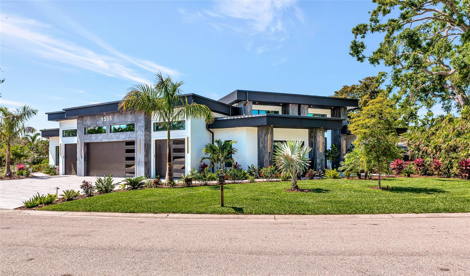 A One-of-a-Kind Modern Estate – Introducing 1555 Eastbrook Dr, an architectural triumph where modern elegance, high-performance design, and luxurious livability converge. This custom-built, single-story residence is a bold statement in style, showcasing a flat roofline, expansive open floor plan, and soaring ceilings that amplify light, volume, and contemporary sophistication. This smart home is wired for seamless living—equipped with an integrated automation system, in-ceiling speakers in every room, surveillance cameras, and a dedicated wall-mounted iPad for effortless control of audio, and security. At the heart of the home, a stunning chef’s kitchen features sleek, flat-panel custom cabinetry and a massive center island—designed to blend beauty and function. The kitchen flows into an impressive great room with sky-high ceilings and expansive glass sliders, perfect for entertaining or unwinding in style. The primary suite is a private retreat, complete with a spa-inspired bath, oversized shower, and dual custom walk-in closets—his and hers—designed for both elegance and organization. Each guest suite offers its own en-suite bath and designer finishes, providing the ultimate in privacy and comfort. Car collectors will appreciate the four-car garage with soaring ceilings, offering ample space for lift systems to accommodate up to four more vehicles or extra storage. Step outside to experience your own private resort: a massive covered lanai fully enclosed with frameless panoramic screen walls for uninterrupted views and cross-breeze airflow. A luxury outdoor kitchen and wet bar make this space ideal for grand-scale gatherings. The oversized pool and elevated spa complete this showstopping outdoor sanctuary. Perfectly positioned near Sarasota’s world-class beaches, fine dining, shopping, and cultural attractions, 1555 Eastbrook Dr is not just a home—it’s a lifestyle statement. Experience rare craftsmanship, future-forward design, and the prestige of owning one of Sarasota’s most distinctive modern residences.
