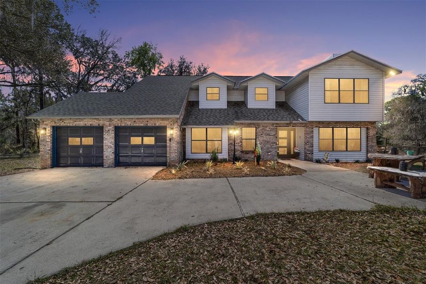 Experience unparalleled privacy with this stunning two-story pool estate, sprawling across nearly four acres on two separate parcels in the heart of Floral City’s Floral Acres. This impressive residence offers over 3,200 square feet of living space, featuring three spacious bedrooms and three baths. The main level features a spacious layout designed for daily living and entertaining. The kitchen is well appointed with quartz countertops, a French door refrigerator with dual ice and craft ice, self-cleaning range with air fryer oven, large undermount sink and a large center island. Thoughtful storage solutions include a built-in spice rack, lazy Susan, large drawers for pots and pans, an appliance closet for small appliances and a pantry beneath the staircase. The kitchen has an eat-in kitchen and flows into the family room with a wood-burning fireplace. A dedicated office provides a private workspace, while a flex space off the pool area, currently utilized as a guest bedroom, includes an armoire that conveys with the property. A full bath with shower is also on the main level, offering convenient access for guests and pool use. A staircase leads to the upper level where all bedrooms are situated, each featuring large walk-in closets. The primary suite offers an open layout with three large windows that introduce natural light. The en-suite bath includes a freestanding tub, walk-in steam shower, double-sink vanity with quartz countertops and two linen closets. The second bedroom is generously sized and features an outer space mural accent wall and a large walk-in closet. The third bedroom also offers substantial space and a large walk-in closet. The upper-level bath serves these bedrooms and includes a double-sink vanity with quartz countertops and a newly remodeled shower. Outdoor living is centered around the private saltwater pool with screen enclosure and expansive covered lanai. Quadruple sliding screen doors open to a fully fenced area that includes a fire pit, garden space and swing set area, creating a functional setting for gatherings and year-round enjoyment. The property also includes a 30-by-40-foot detached metal building totaling approximately 1,200 square feet, suitable for storage, workshop space or recreational equipment, with a 20-by-30-foot concrete pad in front. Major system updates include a roof replacement completed in 2022 and two heating and air-conditioning systems, one serving the upper level and one the lower level, both replaced in 2022. Floral Acres is known for its larger homesites that provide space between residences and flexibility for outdoor use. The neighborhood is not governed by a mandatory homeowners association, offering added versatility for property owners. Floral City, in Citrus County, is recognized for its historic character and natural surroundings. The community includes the Floral City Historic District, known for preserved late 19th-century architecture and oak-lined streets. Outdoor recreation is accessible nearby at the Withlacoochee State Trail, a 46-mile paved multiuse trail, and along the Withlacoochee River for boating, kayaking and freshwater fishing. The property offers a rural setting while remaining within convenient driving distance of Inverness and Brooksville for shopping, dining and services. Tampa International Airport is approximately one hour south, supporting regional and national travel.