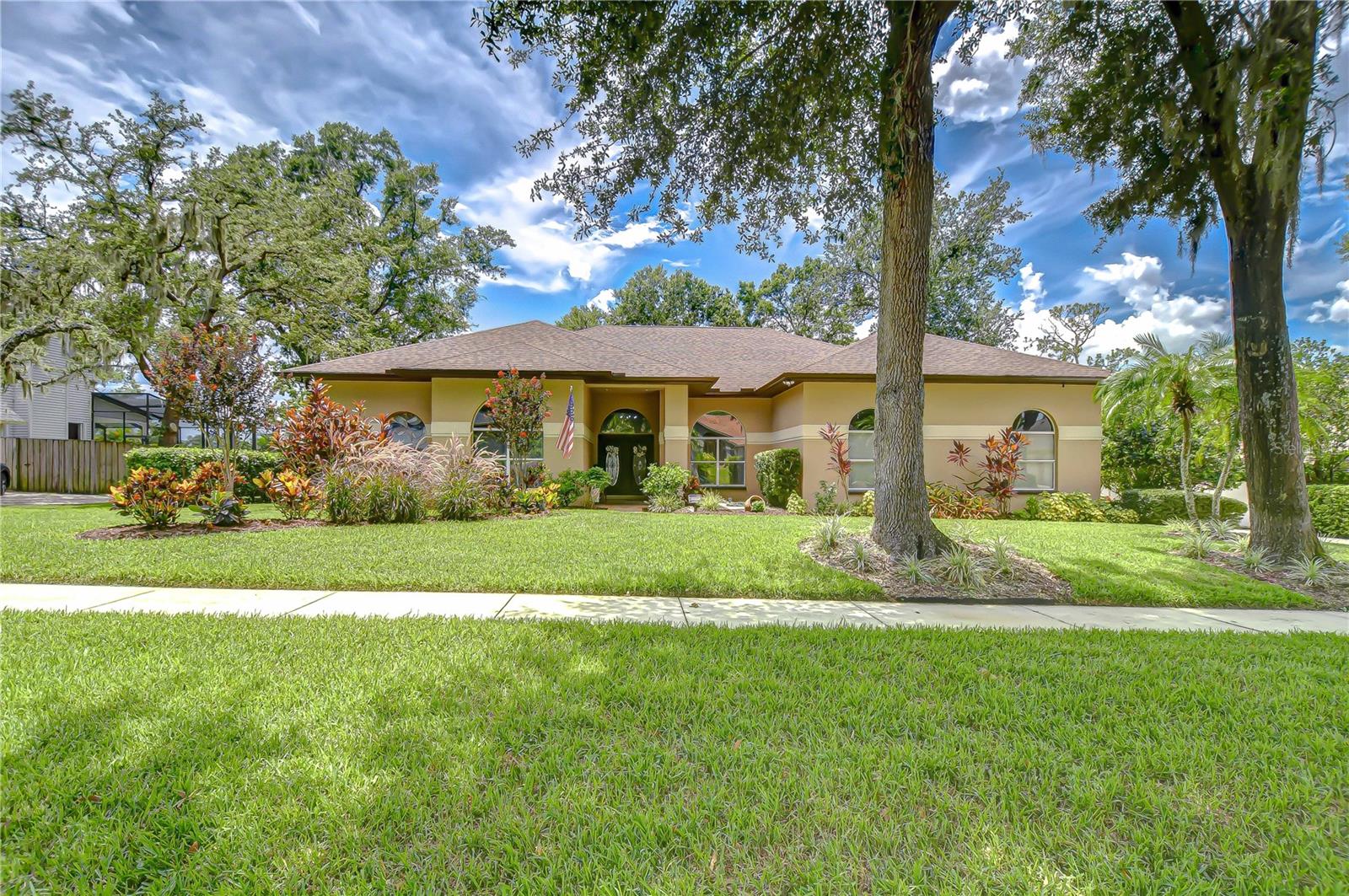 Welcome to a home where modern luxury meets thoughtful craftsmanship. This meticulously remodeled 5-bedroom, 3.5-bath custom residence is perfectly positioned in the quiet, tree-lined community of Oak Landing, celebrated for its mature landscaping, charming streets, and unbeatable location — with convenient access to both Tampa and Orlando. Plus, enjoy the freedom of an optional HOA and no CDD fees. Every inch of this home has been upgraded, blending timeless design, top-quality finishes, and smart functionality to create the ideal living experience. Notable improvements include a new AC, water heater, and whole-home water softener system (2018), stunning 24x24 porcelain/travertine stone tile flooring added in 2018, LED motion-sensor security lighting (2025), and fresh exterior paint completed in 2024. Extensive professional landscaping enhances the lush, tropical curb appeal, featuring a beautiful brick paver front walkway that welcomes you to elegant double leaded glass front doors. Inside, soaring ceilings, abundant natural light, and picturesque views of the pool create a bright, inviting atmosphere. The formal living and dining rooms are ideal for gatherings, seamlessly connected to the heart of the home — the fully remodeled chef’s kitchen. The kitchen, updated in 2018, features rich hardwood cabinetry with pull-out drawers, elegant tile backsplash, rare Fantasy Brown granite countertops, prep island, bar seating, and sleek stainless-steel appliances, including a built-in wall oven — a perfect space for entertaining and everyday enjoyment. The spacious family room offers warmth and functionality with its stunning stacked marble fireplace, custom built-ins, and convenient wet bar, all flowing effortlessly to the outdoor living spaces. The private primary suite is tucked away on its own wing, offering French door entry, updated engineered hardwood floors, direct lanai access, and a spa-like, remodeled bath complete with a cast iron clawfoot tub and oversized dual-shower head walk-in shower. The flexible split-bedroom layout includes a guest suite near the front of the home, ideal as an office, hobby space, or private guest quarters. Three additional bedrooms are located on a separate wing — ideal for multi-generational living — with one bath offering direct pool access and another featuring an ADA-accessible roll-in shower. Throughout the home, volume ceilings, upgraded finishes, and expansive windows create a bright, open feel. Multiple sliding doors connect the interior to your private outdoor retreat, featuring a saltwater pool, outdoor kitchen with sink, propane grill, and bar seating, all protected by a rescreened lanai (2025). An additional storage room on the pool deck provides practical space for pool equipment and supplies. The fully fenced backyard offers peace of mind for pets and little ones, while new sod, mature trees, vibrant plants, and extensive tropical landscaping create a private paradise perfect for relaxing or entertaining. This home has been transformed from top to bottom, offering modern upgrades and exceptional living in one of Brandon’s most desirable neighborhoods. Don’t miss your opportunity to experience this remarkable, completely remodeled home — schedule your private tour today! Copy and paste this link to tour the home virtually: my.matterport.com/show/?m=aMW77Xvdmki&mls=1