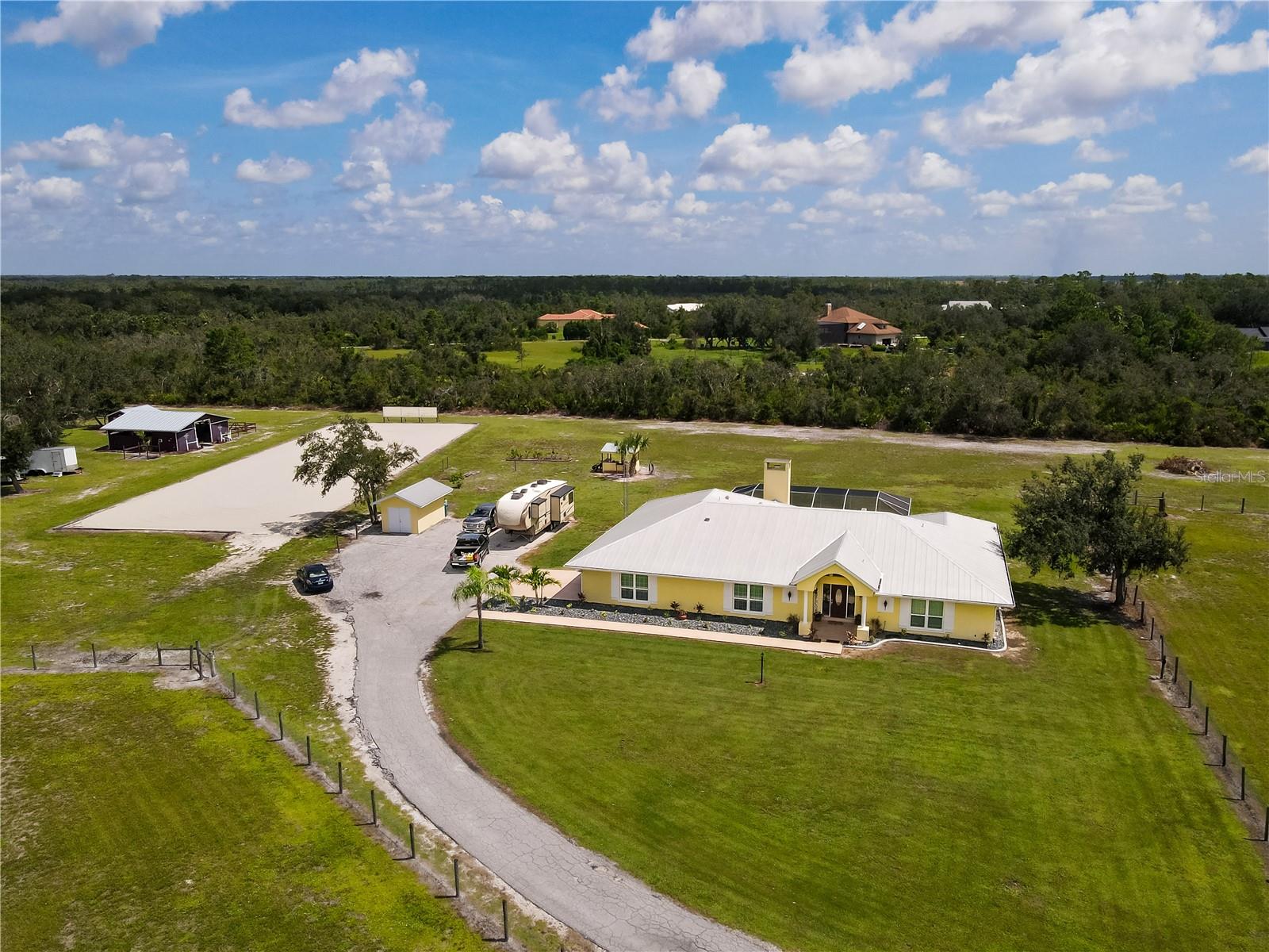Well maintained 4 Bedroom, 2.5 Bathroom, Pool home with a den, located in the desirable Prairie Creek Park community. OVER 7 fenced acres, perfect for equestrian family, hobby farmers, or anyone seeking a peaceful country lifestyle. NO FLOOD REQUIRED! CLICK ON THE VIRTUAL TOUR LINK 1 FOR THE VIDEO AND VIRTUAL LINK 2 FOR THE 3D TOUR. This home has a sunken living room with a stone accent wall that serves as a unique focal point, while natural light pours in through a large glass slider that opens to the lanai—perfect for seamless indoor-outdoor entertaining. Just off the living room is a flexible office space that flows into the kitchen to use as an additional room to suit your needs. The kitchen offers ALL stainless-steel appliances, ample counter space, abundant cabinetry, a coffee/wine bar, breakfast bar, closet pantry, and built-in desk. The spacious master suite has two glass sliders—one opening to the lanai and the other to the backyard—for plenty of natural light and private outdoor access. The en-suite bathroom has dual closets, a double vanity with dedicated makeup space, a relaxing jacuzzi soaking tub, and a walk-in glass-door shower. Just off the master suite, a versatile guest room features a walk-in closet and convenient access to a nearby half bathroom. With a private entry from the master, this flexible space is perfect as a nursery, media room, meditation/exercise room, or additional guest quarters—tailored to suit your lifestyle. The additional guest rooms are on a split floor plan, providing plenty of privacy, with built-in closets and a shared guest bathroom with a shower/tub combo and access to the lanai. Start your day with a peaceful cup of coffee or unwind with your favorite evening beverage on the patio with tranquil pasture views, plenty of space for entertaining and an above ground spa. Enjoy a newly resurfaced, oversized 8-foot deep, pool & pool deck with plenty of room for soaking up the Florida sun, surrounded by a 2025 pool cage. The 34'x30' barn, complete with a new 2024 roof and gutters, is thoughtfully equipped for all your equestrian needs. It features four horse stalls—including a spacious foaling stall that can easily be converted into a fifth stall—along with a feed room, an A/C-equipped tack room with a refrigerator, high-powered fans, a hot water wash rack, and a full dressage arena with mirrors. The land features four fully fenced paddocks/pastures, offering ample space for animals or future agricultural use & a pond. A storage shed, covered storage area for your mower and tools, and a hay storage shed provide excellent utility and organization for all your outdoor needs. The property is enhanced by fresh, lush landscaping, adding curb appeal and a serene natural backdrop. A paved parking pad offers a convenient and secure place to park larger vehicles, trailers, or equipment. 2015 METAL ROOF - INSULATED STORM WINDOWS - TWO A/C UNITS - ALL FURNITURE & GARAGE APPLIANCES ARE NEGOTIABLE. Prairie Creek offers 22 miles of groomed green belt horse riding trails for the horse enthusiast, where you can experience the pinnacle of luxury living; privacy, access to hiking and horseback riding trails. Prairie Creek Park community also backs up to Shell and Prairie Creeks—offering kayaking and boating access just a mile away Punta Gorda's airport, vibrant downtown, boutiques and dining options are just 15 minutes away, with easy access to I-75 and boating, fishing, and golf nearby. Schedule your showing TODAY!