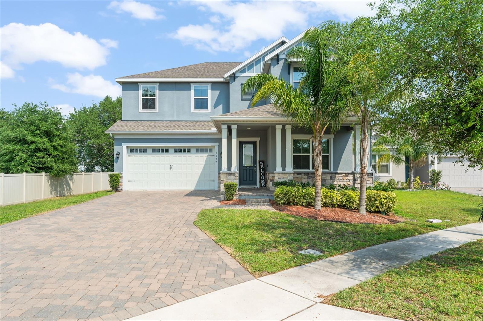**This property qualifies for a closing cost credit up to $9,100 through the Seller’s preferred lender.**PRICED BELOW APPRAISED VALUE -Welcome home to this breathtaking two-story home in the heart of St. Cloud, FL. This 4-bedroom, 3.5-bath residence blends modern elegance with coastal charm, featuring stone accents, a paved driveway, and a welcoming front porch. Step inside to find an inviting bonus space with French doors, perfect for a home office or formal sitting area. Crown molding and ceramic tile flooring flow throughout the first floor, leading you to the open concept living, dining, and kitchen areas with a water softening system. The spacious living room boasts a custom built-in entertainment center surrounding an electric fireplace with a mantle, while sliding glass doors open to the backyard oasis. The kitchen is a chef’s dream, complete with stainless steel appliances, sleek gray lower cabinets, white upper cabinetry, black hardware, and a dining nook with serene backyard views. Upstairs, a versatile loft space connects to four bedrooms, three bathrooms, and a convenient laundry room. The luxurious primary suite features a walk-in closet and a spa-like ensuite with a double sink vanity and an oversized glass-enclosed walk-in shower. Out back, enjoy Florida living at its finest with a covered patio, an outdoor kitchen, and a sparkling pool with a sun shelf and fountain feature—all surrounded by lush green space. Don't miss your chance to own this exceptional home in a sought-after location. Schedule your private tour today!