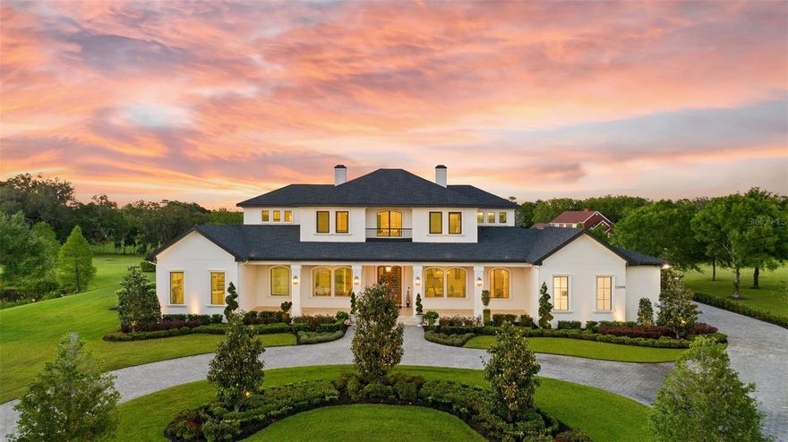 Upon first glance, the impeccable attention to detail, exquisite finishes, and a joy of symmetry are immediately apparent, setting a theme of enjoyment in this magnificent home. *Use 10400 Oak Canopy Drive for the gate.  Spanning 7,406  square feet of sheer entertaining perfection, this residence is situated pondside on two scenic acres within the ultra-exclusive Stonelake Ranch. The home features five bedrooms, five full bathrooms, two half bathrooms, an office, and a plethora of special touches, making it standout. From the moment you approach, the use of premium materials such as fine wood, metal, and stone is evident. The estate is positioned on its acreage to maximize privacy and includes a fishing pond, extensive green space, and open backyard views.  A grand driveway of granite colored cobblestone cement pavers leads to the impressive custom smokewood doors, which are perfectly complemented by the tongue and groove ceiling of the expansive travertine front porch. Entering the home, you are met with soaring 24-foot ceilings and the elegant sight of a Midwestern-style oak and wrought iron staircase, setting the stage for the formal dining and living rooms. These areas are distinguished by a crafted stone gas fireplace and wide plank hardwood floors throughout. The heart of the home is the chef’s dream double island kitchen, fully equipped with top-of-the-line appliances and designed for both functionality and luxury. This includes Café Double French Wall Ovens, a 48" Sub-Zero refrigerator, and a 36" 6 burner grill, and dual Bosch dishwashers. The kitchen facilitates superb guest service with its island breakfast bar, breakfast nook, butler’s pantry with a 48-bottle Zephyr wine fridge, and a specialty nugget  ice maker.  The adjoining massive great room, with its exposed smokewood beams and stone-faced gas fireplace, seamlessly extends into the expansive screened lanai, pool, and outdoor kitchen, enhancing the indoor-outdoor living experience. Here pocketed sliding doors blur the lines between in and out offering all a picturesque view of sunset over the pond from poolside. The beautifully appointed and finished salt water pool is surrounded by a sea of light ivory French pavers and features a heated spa, customizable RGB lighting, and pool alarm.  The estate’s first-floor primary suite is a true sanctuary, featuring a breathtaking picture window view of the pond from the freestanding bathtub, luxurious dual vanities, a step-in shower, dressing lounge, private yoga room, and direct pool access. 
The first-floor secondary suite also spares no luxury, equipped with expansive dual vanities, a garden tub, and a step-in shower, ensuring comfort and style. Upstairs, additional guest rooms with ensuite bathrooms offer spectacular views and are complemented by a loft lounge overlooking the foyer and pool area. Completing this extraordinary home are a finely detailed office, a dual-functional mudroom/laundry room with a pet wash station, and a spacious four-car garage. Advanced features such as a 500-gallon private reserve propane tank, comprehensive security system, and potential for an elevator installation ensure both convenience and peace of mind. Community amenities like equestrian trails, a lakeside lodge, and various recreational courts add to the luxurious lifestyle.