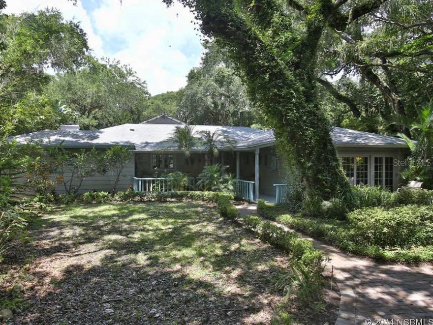 4 Bedroom, 2.5 bath beachside pool home & guest house on nearly 2 acres- Under canopy of crooked oak & fragrant magnolia, this property can be best described as a sanctuary of sorts. Winding brick paver drive leads to the main house, spacious in its own right at over 2600 sqft under-air. The open floor plan paired w/massive window sliders along the rear brings a flood of natural light, melting inside to outside near seamlessly. Built-in buffet w/ glass curio adds room separation w/o impediment of view. Custom built-in library frame a wood-burning fireplace in spacious living room. Truly unique all black âtwo-chefâ kitchen disappears with the lights off in the evening, leaving nothing but nighttime views unhampered by artificial light. Aesthetics aside, the kitchen also boasts custom cabinets, 3 Fisher-Pakel dish-drawers, SubZero refrigerator, Thermador cooktop & silestone counters.  Master suite features a private deck, walk-in California closet, sitting room w/ large jetted tub & over-sized shower.  The massive brick paver patio & pool sit under a soaring screen enclosure w/ partial acrylic roof.  A paver walkway leads from the pool to the guest house w/ half bath, private deck & fire pit as well as a Har-Tru bocce ball court. Tucked up in the trees, sits a multi-level deck looking out on protected wetlands & wildlife. Deck has a bench swing, built-in seating, w/ stair access to upper level.  Nearby shopping, dining & entertainment on 3rd Ave & Flagler Ave, walking distance to the no-drive beach & minutes to I-95 & I-4. Buffered from the bedlam of daily life, behind curtains of palm & bamboo, beneath a rich canopy of mature magnolias & oaks, sits a home unlike any other, a hidden retreat & solace found. ;Water: City