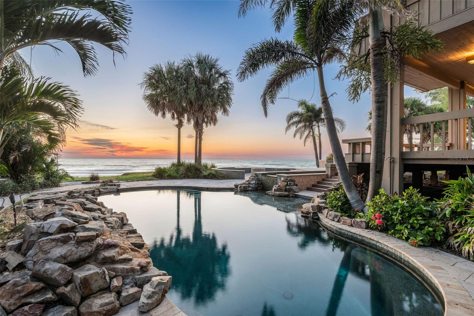 Nestled on OVER AN ACRE of breathtaking PRIVATE BEACHFRONT PROPERTY, this uniquely designed residence at 400 Gulf Blvd is a masterpiece. With 160 FEET of pristine GULF VIEWS, this one-of-a-kind home features 5 bedrooms and 4 bathrooms, offering unparalleled vistas of the Gulf of Mexico. The living room, adorned with a two-sided beautiful stone fireplace, boasts vaulted ceilings, setting the stage for elegant gatherings. The kitchen's views will inspire any at-home chef.
The office becomes a genuine sanctuary, where the two-sided fireplace, bespoke library loft, and unmatched water views seamlessly converge to create a refined yet cozy ambiance. Two generously sized bedrooms on the lower level offer privacy, each leading out to a secluded porch area. Ascend to the upper floor to discover the magnificent master suite, complete with a private balcony, dual walk-in closets, an expansive walk-in shower, and a luxurious soaking tub that offers breathtaking views of the beach—a true haven. An additional two-bedroom suite on the second floor features a comfortable living area, a private balcony, and a full bath with two bedrooms.
Step outside onto the one-of-a-kind wrap-around deck, offering multiple levels for outdoor enjoyment. The stone-adorned pool area features multiple cascading waterfalls, an elevated connected spa, and a cozy fire pit, all framed by the stunning backdrop of the Gulf of Mexico. The property is complemented by an expansive brick paver driveway and lush landscaping, creating a truly unique coastal paradise. Situated in the highly coveted Belleair Shores, this residence provides the rare opportunity to own prime real estate. Don't miss this chance to own an extraordinary home in one of the most sought-after locations on the West Coast of Florida.