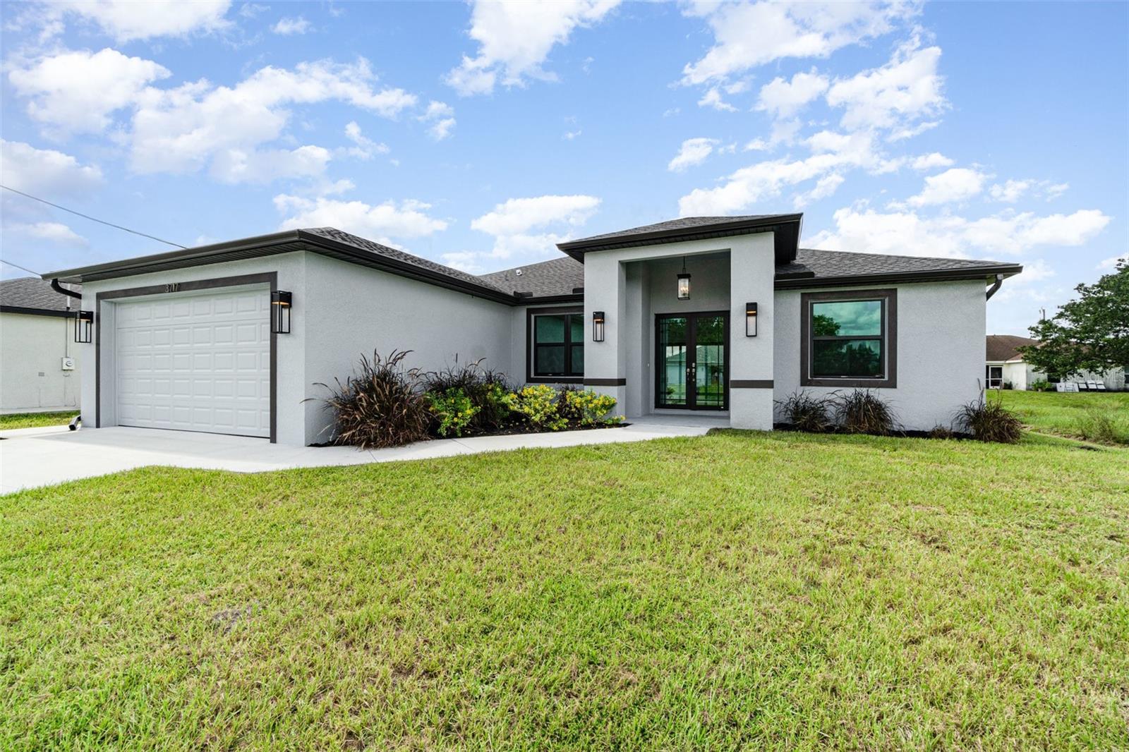 Welcome to your dream home, a brand-new construction in a prime central location in Lehigh Acres. This home offers a perfect mix of luxury, style, and convenience, built with exceptional quality and attention to detail. It's designed for modern living and peace of mind. This spacious 3-bedroom, 2-bathroom residence features a versatile den that's perfect for a home office or cozy reading nook. The split floor plan ensures privacy, with the luxurious primary suite tucked away on one side of the home. The primary suite is a true retreat, boasting an elegant tray ceiling and two spacious walk-in closets. In the spa-like primary bathroom, you can relax in a standalone soaking tub or enjoy the sleek, frameless shower. The bathroom also features two separate sinks and vanities, along with a private water closet. The heart of the home is the chef's kitchen, which features high-end GE brand stainless steel appliances, elegant quartz countertops, and soft-close cabinetry with a beautiful tiled backsplash. This space flows seamlessly into the large great room, making it ideal for entertaining. Throughout the home, you'll find 8-foot doors, decorative lighting and fans, and stunning large tile flooring. The living room also has a tray ceiling, adding an extra touch of sophistication. Beyond the stunning interior, you'll find top-of-the-line features for comfort and security. Hurricane impact windows and doors provide superior protection and energy efficiency. The exterior features a beautifully landscaped yard with lawn irrigation, which you can view from the screened-in lanai. The builder even added an integrated pest control system, allowing for easy access and a pest-free home. This fantastic location puts you close to everything you need. You're just a short drive from RSW International Airport, SR-82, and I-75, making travel a breeze. Enjoy the excitement of Spring Training for the Boston Red Sox and Minnesota Twins, or explore the area's excellent shopping and dining. When you're ready for a day in the sun, the beautiful Gulf Coast beaches are not far away. This home is more than just a place to live—it's a lifestyle. Come see what makes this brand-new home so special.