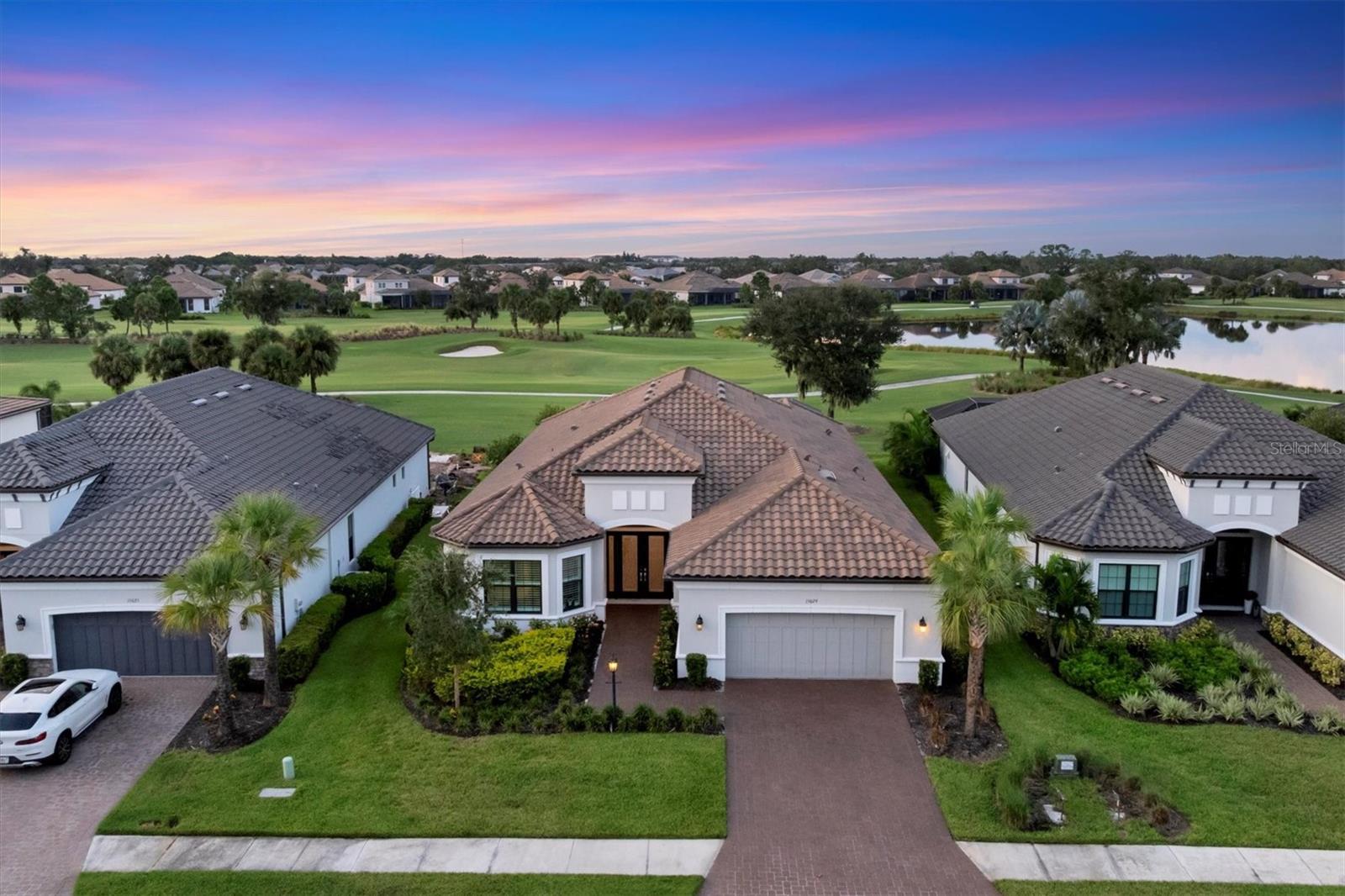 EXQUISITELY DESIGNED POOL HOME IN THE PREMIERE GOLF COMMUNITY OF ESPLANADE AT AZARIO, OFFERING MAGNIFICENT GOLF COURSE VIEWS AND GOLF CLUB MEMBERSHIP IS INCLUDED! This beautifully appointed residence showcases a unique blend of luxury and design, featuring a spacious Great Room overlooking picturesque golf course vistas that seamlessly transition to an exceptional outdoor living space thoughtfully designed for contemporary living. Expansive Travertine Shellstone Lanai surface, Covered Gathering areas, an OUTDOOR KITCHEN WITH BAR, GAS FIREPLACE, SPARKLING SALTWATER HEATED POOL AND SPA with Pebbletec finish and Panoramic Clear Vue Screen overlooking golf and water views is ideal for embracing the Florida lifestyle. Elegant interior finishes include PORCELAIN TILE FLOORS, TRAY CEILINGS, CROWN MOLDING, QUARTZ COUNTERTOPS, 8 FOOT DOORS, and IMPACT WINDOWS AND DOORS throughout along with plantation shutters and motorized shades in great room and kitchen. This area integrates a dining space and a gourmet-style kitchen, perfect for both entertaining and relaxation. The chef's kitchen is equipped with wood cabinetry, tile backsplash, a generous island with a breakfast bar for casual dining, additional prep sink, GE MONOGRAM APPLIANCES including a built-in refrigerator and oven, 6 burner gas cooktop with pot filler, professional series range hood with warming lamps, R.O. water filtration, walk-in pantry, and a beverage center. Retreat to the private owner's suite with bay window providing serene outdoor views and a lavish bath featuring a dual bowl vanity with dedicated makeup area, an expansive walk-in shower with multiple shower heads and a generous built-in closet. The desirable split bedroom and bath plan ensures privacy for family and guests, with an ensuite bedroom and bath and front bedroom adjacent to the hall bath which includes a king-size Murphy bed. The versatile study is ideal for a home office, game room, or your favorite hobbies. A separate laundry room includes a convenient drop-in sink, upper and lower cabinets, and front-load washer and dryer. The three-car tandem garage, complete with an epoxy finish floor, offers ample space for a golf cart. Complimented by a paver drive and walkway, outdoor lighting, gutters, barrel tile roof, whole house KOHLER GENERATOR and TANKLESS GAS WATER HEATER with RECIRCULATING PUMP, this exceptional home is conveniently situated across the street from a satellite pool, dog park, and community garden. The highly amenitized community boasts a socially active resident CLUBHOUSE, state-of-the-art FITNESS CENTER, Spa and SALON, TENNIS and PICKLEBALL courts, RESORT STYLE POOL with BAHAMA BAR, CULINARY CENTER, BARREL HOUSE BISTRO and an 18-HOLE CHAMPIONSHIP GOLF COURSE, PRO-SHOP and AQUA DRIVING RANGE. Experience life in Lakewood Ranch, the nation's #1 multi-generational community, where you are minutes to dining, shopping and events at Lakewood Ranch Main Street and Waterside Place. The location offers close proximity to the UTC Shopping Mall, Benderson Rowing Park, New Mote Marine Aquarium, and I-75 for convenient travel north and south, and you are approximately 30 minutes from downtown Sarasota's vibrant cultural venues, diverse dining options, and our stunning Gulf Coast Beaches!