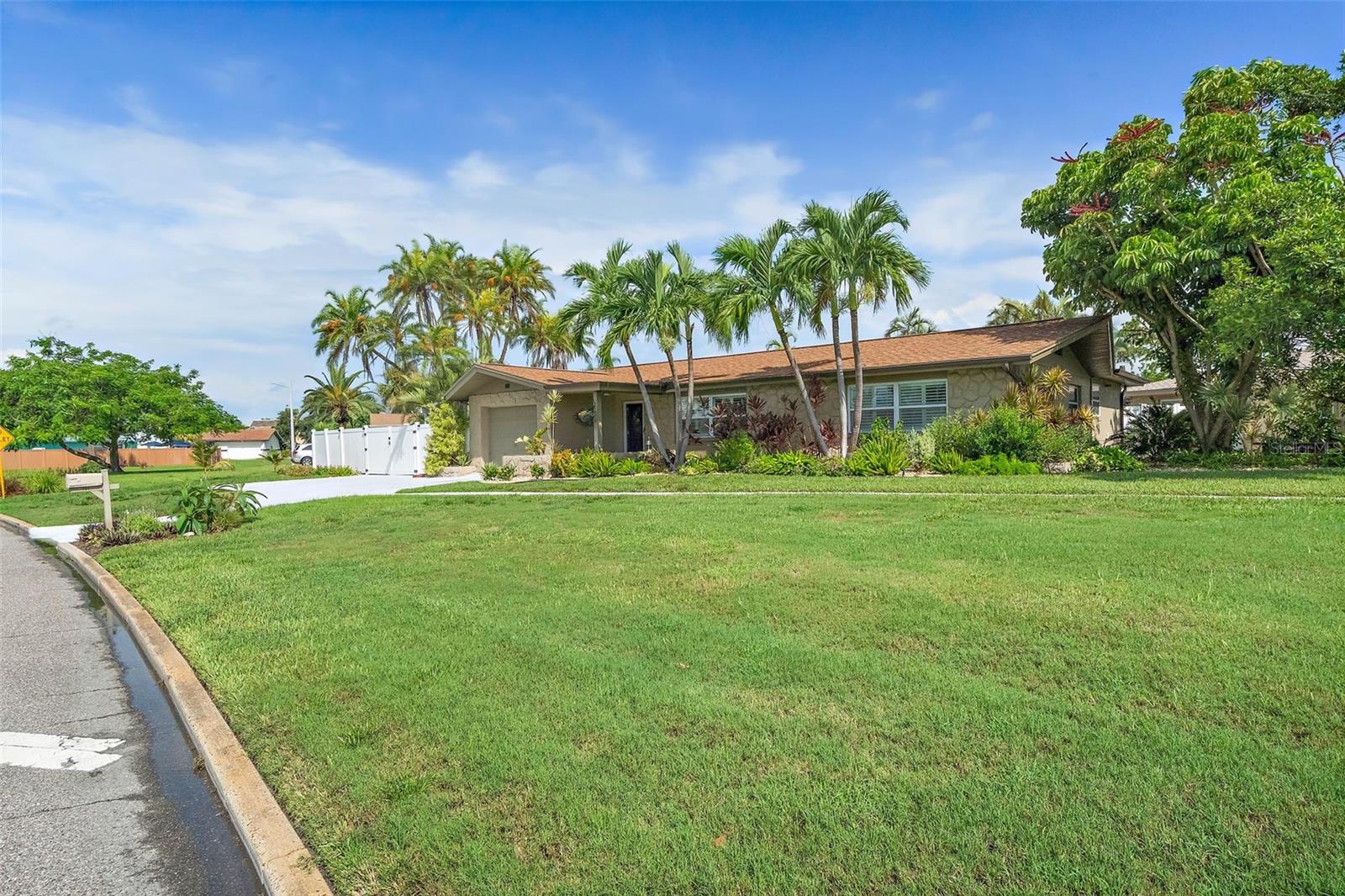 Fabulous Pool Home nestled in the heart of the coveted Tierra Verde community, this stunning home offers the perfect blend of modern updates and tropical charm. Located at the southern tip of St. Petersburg, Florida, Tierra Verde is renowned for its laid-back boating and fishing lifestyle, with direct access to nature and the beautiful Fort De Soto Park. Step inside to discover a fully updated kitchen featuring solid surface countertops, custom cabinetry, stainless steel appliances, a vent hood, and recessed lighting, all enhanced by high-quality fixtures. Both bathrooms have been elegantly updated with custom vanities, granite countertops, tile shower enclosures, and stylish fixtures and lighting. The home boasts diagonal tile throughout, creating a seamless flow from room to room. The spacious laundry room is equipped with built-in cabinetry for added convenience and storage. Outside, you'll find your own private tropical oasis. The lagoon-style pool is surrounded by lush landscaping, offering complete privacy, while the expansive lanai and pergola provide the perfect setting for outdoor dining or relaxing. There’s also an additional parking pad ideal for boat or RV storage. With its prime location, you'll have easy access to all Tierra Verde has to offer. The pristine Gulf beaches are just a short bike ride away, and you're only moments from some of the area's best fishing and nature spots. Plus, this home has not been affected by flooding, offering peace of mind for years to come. Whether you're looking for a seasonal retreat or a permanent residence, this home offers the ideal balance of luxury, comfort, and convenience. Pride of ownership is evident throughout – it’s a must-see!