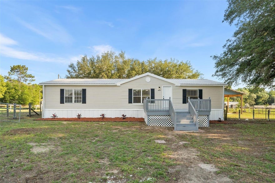 Looking for space, freedom, and a home that’s completely move-in ready without the high price tag? This beautifully renovated manufactured home sits on a fully fenced 1.25-acre lot with Rural Residential zoning, meaning zero HOA restrictions and you get to bring the horses, chickens, or livestock—there’s plenty of room to roam, park your work trucks, and expand your footprint. The exterior features low-maintenance vinyl siding, front rain gutters, a secure wire perimeter fence, and a 3-year-old roof for ultimate peace of mind. Step past the freshly painted front wood deck and into a wide-open floor plan loaded with modern upgrades. High-traffic, waterproof vinyl flooring runs throughout the entire interior, making cleanup easy after a hard day's work. The welcoming main living area centers around a cozy wood-burning fireplace, with energy-efficient ceiling fans installed throughout the home to keep monthly utility bills low. The kitchen is nicely appointed with solid quartz countertops, a deep apron-front farm sink, and premium soft-close wood cabinets. It comes fully equipped with a brand-new stainless steel appliance package, including a refrigerator, microwave, smooth-top range, dishwasher, and a garbage disposal. Just off the cooking area, a dedicated laundry pantry adds convenient extra storage for supplies. The split-bedroom floor plan ensures privacy, with every single bedroom featuring its own independent walk-in closet for maximum storage layout. In the primary suite, the private master bathroom offers a spacious setup complete with dual sinks and a generous walk-in shower. Outside, the massive 35x22 wood-construction pole barn with a durable metal roof offers the ultimate workspace or equipment storage area. Built with half the floor on a solid concrete slab and the other half dirt, it’s ideal for parking tractors, storing trailers, or whatever works for you! You have total freedom to add a secondary workshop, detached garage, or accessory building down the road whenever you are ready to grow.