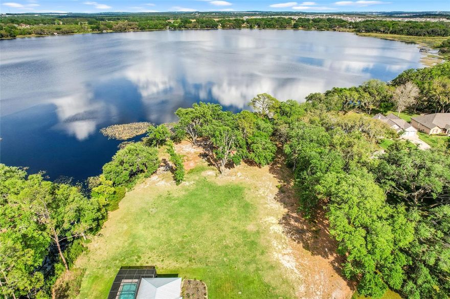 Discover the perfect canvas for your dream home with this exceptional property boasting 164 feet of direct lakefront and an additional 178 feet of canal frontage on the serene Groveland Chain of Lakes. Imagine waking up to panoramic views of the lake and enjoying your own private dock, ideal for boating and fishing enthusiasts.  This rare offering is one of the few direct lakefront properties in the area, presenting an unparalleled opportunity to embrace the natural beauty of the surroundings. Spend your days biking along scenic trails and immersing yourself in nature’s splendor.  Conveniently located just a short distance from the Florida Turnpike entrance and with NO HOA restrictions, this is your chance to visualize and create the home you’ve dreamed about for years. Don’t miss out on this unique opportunity to build your lakeside retreat!