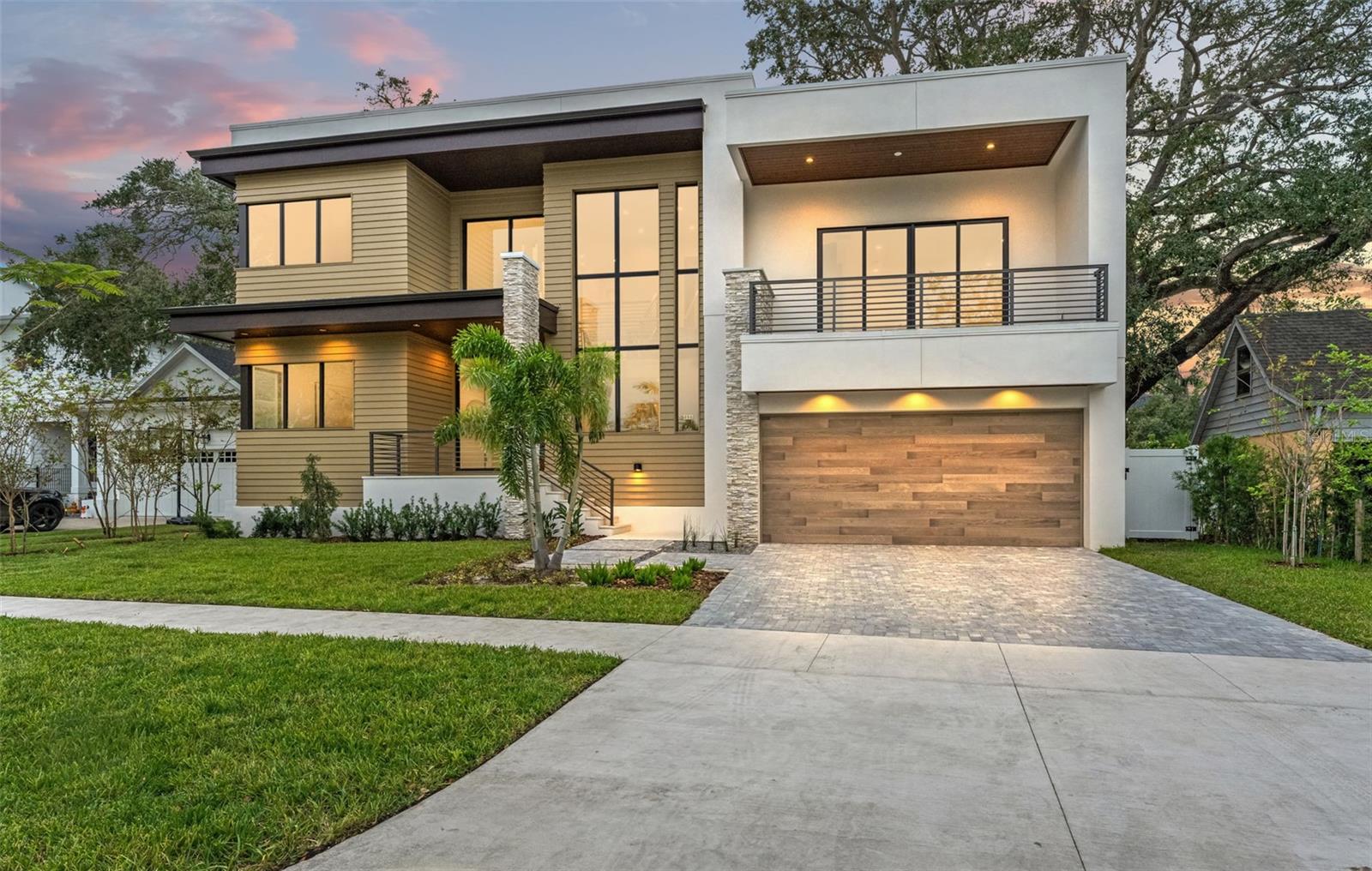 “Le Alberi Modern” – The Modern Trees epitomizes our latest development in the prestigious waterfront enclave of Davis Islands. This exceptional residence merges unparalleled design, masterful craftsmanship, efficient use of space, and meticulous attention to detail, promising to captivate and inspire. Spanning 5 bedrooms, 5.5 baths, a study, and a media room across 5,200 sq ft of luxurious living space, it offers a sanctuary of contemporary elegance. Central to the home’s ethos is its emphasis on natural light, achieved through expansive floor-to-ceiling windows that bathe the interior in sunlight. Upon entry, the 30-ft soaring foyer welcomes you, complemented by a floating staircase with wood treads. The architect’s vision unfolds, revealing direct sightlines to the rear outdoor spaces. The main level is anchored by a spacious dining area featuring built-in cabinets, a beverage fridge, and elegant wood shelving. This harmonizes with the stunning gourmet kitchen, boasting Quantum Michelangelo quartz countertops, dual islands, and sleek Wellborn European cabinets with flush doors. A striking ‘Floating Light tray’ crowns the central island, while a Thermador appliance suite, oversized walk-in pantry with built-ins, and a coffee bar elevate functionality. Casual seating at the waterfall island enhances the kitchen’s allure, fostering a perfect balance of intimacy and openness. The main level also includes a generously sized guest bedroom, a full guest bath with a walk-in shower, a separate dedicated pool bath as well as an oversized study/office. The living room exudes warmth with its 72” linear gas fireplace, set against a floor-to-ceiling accent wall adorned with contemporary tiles. Glass sliding doors open onto the expansive covered lanai, complete with an outdoor kitchen boasting a gas grill, sink, and ample storage, overlooking a raised sundeck and pool with a cascading spa. Ascending to the mid-floor level reveals a versatile bonus room with a half bath and private balcony, offering flexibility as a media, exercise, or game room. The second floor hosts a lavish primary suite featuring a freestanding soaking tub, large walk-in shower, and a quartz vanity with dual sinks. The pièce de résistance is the expansive 21' x 12' walk-in closet with built-in island and extensive shelving. Three additional guest bedrooms, including an en-suite and a Jack-and-Jill s setup complete this level, alongside a full-sized laundry room. Additional features include an elevator, spray foam insulation, impact windows dual Trane 15.4 SEER air conditioners with heat pumps, natural gas plumbing, and two tankless water heaters with a recirculating loop. The home is prewired for a 200-amp Kohler home generator, a 50-amp electric vehicle charging circuit, security cameras, and surround sound systems in the living area, bonus room, and lanai, ensuring both security and entertainment. Located on the waterfront community of Davis Islands, this residence offers an unparalleled lifestyle in a vibrant, walkable community favored by professional athletes, executives, and families alike. The neighborhood is home to a wealth of amenities, including Marjory Park Marina, the Sandra Freedman Tennis Complex, the historic Roy Jenkins pool, and Peter O Knight Airport and a variety restaurants and shops. With its prime location just minutes from Downtown Tampa, Water Street, and the Tampa Riverwalk, this home truly offers the best of both island living and urban convenience.