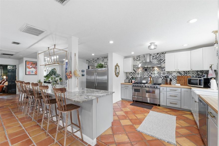 One or more photo(s) has been virtually staged. Recently updated with new double-pane, Energy Star-rated tinted windows and a fully resurfaced saltwater pool in 2025—complete with a state-of-the-art pool cleaning vacuum—plus HVAC in 2021, this one-of-a-kind 4-bedroom, 3-bath split-plan home sits on a generous half-acre lot just steps from Brooksville’s charming historic district. The formal living room features real wood floors, vaulted ceilings, chair rail with picture frame molding, a striking white stone wood-burning fireplace, and French doors opening to a covered rear porch with an entire wall of customizable slat-wall storage. The chef’s kitchen showcases authentic Saltillo tile floors, stainless-steel appliances, two sinks, two dishwashers, two ovens (gas and electric convection), and a 48” professional range with six gas burners. The oversized 15-foot granite island seats 6–8 and includes its own sink, dishwasher, and abundant cabinetry, while the main wall offers butcher block counters, decorative tile to the ceiling, a white double farmhouse sink beneath a large window overlooking the backyard and pool, supersized refrigerator and freezer, dedicated coffee bar, and a floor-to-ceiling glass-door pantry with gold accents. Cabinets feature soft-close doors and drawers, pull-out shelves, and a lazy Susan. Step down to the attached family room with matching Saltillo tile, crown molding, a wood-framed glass door to the rear, a wall of windows, and extensive built-ins, while the formal dining room includes real wood floors, chair railing, crown molding, and a large front-facing window. The primary suite offers real wood floors, crown molding, chair railing, a wall-spanning front window, a walk-in closet with custom organization, and an ensuite featuring marble-like tile, cultured marble vanity with gold hardware, vintage oval mirror, and a fully tiled step-in shower with built-in bench and glass shelving. The remodeled guest bath (2020) includes crown molding and a step-in shower with bench and niche. The mudroom features matching Saltillo tile, utility sink, extra storage, washer and dryer, and side exterior access to parking. Three additional bedrooms include crown molding; two offer built-in closet systems and real wood floors. The third bath includes dual vanities, granite counters, tub/shower combo with window, vintage folding mirror with hidden storage, and gold towel hooks. Outdoors, the expansive front yard and long driveway create openness and privacy, while the elevated oversized front patio is perfect for morning coffee, gardening, and peaceful wildlife views from the wooded area across the street. The huge fenced backyard features a 10.5-foot-deep saltwater pool with light and advanced cleaning system, newly installed landscaping, extra-large firepit with string lights, hammock space, mature trees, kumquat, loquat, and banana trees, philodendrons, shampoo ginger, a climbing tree, large shed, and chicken coop with run. A buried invisible electric dog fence allows pets to roam freely while preserving the clean, open look of the front yard without visible fencing, and the front garden is supported by irrigation to keep landscaping lush. Downtown Brooksville is just 0.1-0.2 miles away; just a short stroll to the charming local shops, restaurants, community events, library, public tennis courts, playgrounds, and Hernando High School. You’ll also appreciate the quick access to Tom Varn Park and the area’s stunning natural springs, all just minutes from your doorstep.