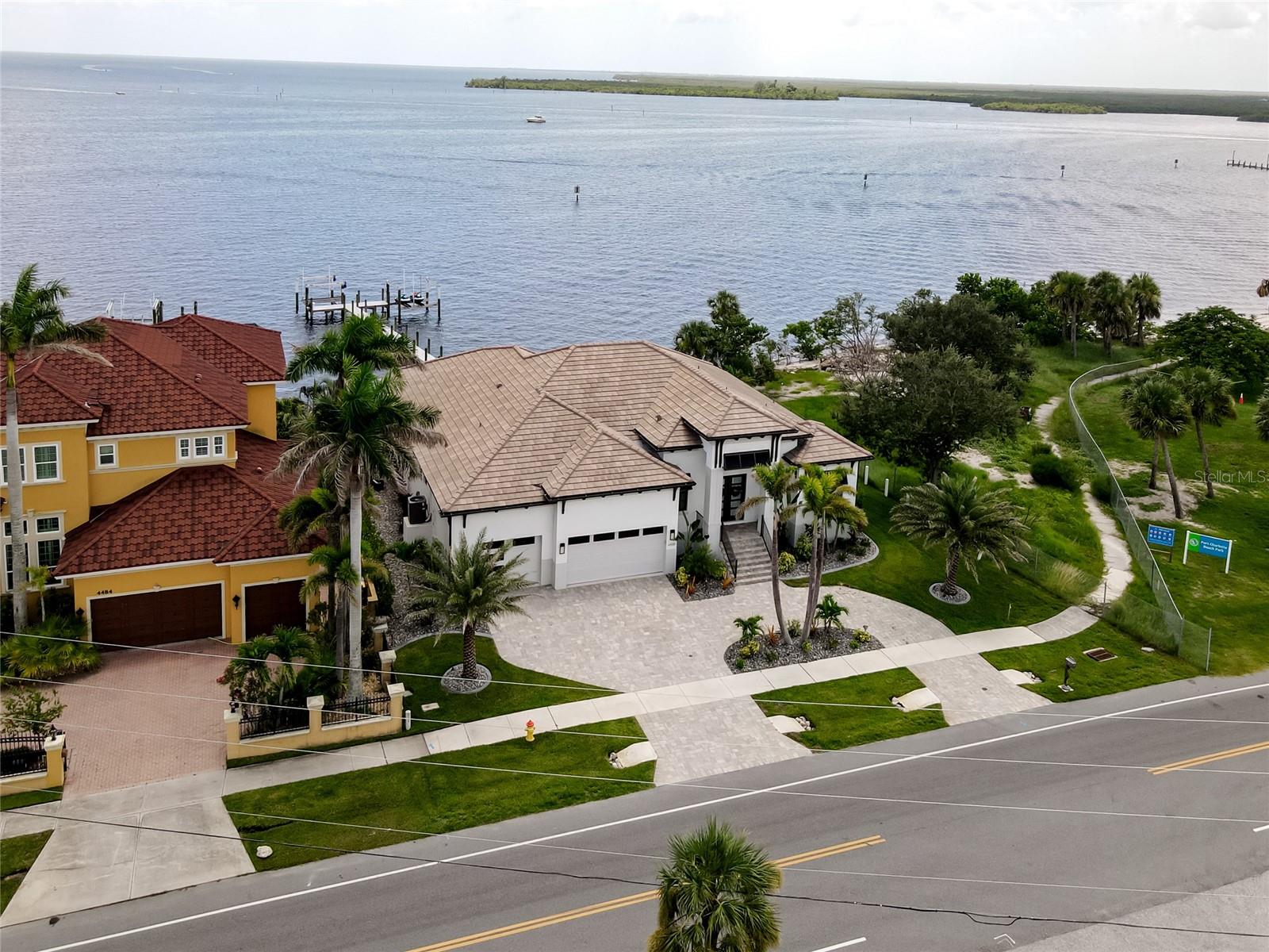 Welcome to your sun-drenched slice of coastal paradise! Situated directly on Charlotte Harbor, this custom new construction (2023) masterpiece was designed to embrace true waterfront living with elegance and ease. From the moment you step through the grand double glass entry doors, you're greeted by soaring 13-foot coffered ceilings, sunlit open spaces, and exquisite tile flooring throughout.
The heart of the home is an Executive Chef’s Kitchen boasting over $100,000 in luxury upgrades. Double Cambria Britannica Quartz islands with stunning waterfall edges, soft-close painted hardwood cabinetry with LED accents, and a premium appliance (similar to Sub-Zero) package make this kitchen as functional as it is striking. A wine “room” steals the show with a full-height wine fridge, cheese drawers, as does the sleek Euro-folding glass doors, off the dining area, that brings the outdoors in.
Step into the primary suite, where sliding glass doors open directly to the lanai, pool, and harbor beyond. The expansive master bathROOM offers spa-level relaxation, with a freestanding tub, walk-in shower, double vanities, and two custom California-style walk-in closets.
Need a flex space? A private office overlooking the harbor makes an ideal retreat—whether you're working, painting, practicing yoga, or simply soaking up the view.
Fully furnished with over $150,000 in upscale ARHAUS and Ethan Allen furniture, this home is move-in ready and thoughtfully designed for comfort and style. Energy efficiency is key with added insulation and an in-wall pest defense system. Coastal-inspired Bahama shutters grace every interior window.
Outside, the true Florida lifestyle unfolds. Entertain beneath wood-paneled ceilings in your covered lanai with full outdoor kitchen, dining and lounge areas. Dive into your custom infinity-edge heated saltwater pool with an 8-foot spa, surrounded by travertine decking. Follow stone steps down to your private waterfront patio with fire pit, flower boxes, and built-in seating. It is the perfect spot for golden hour sunsets.
A 140-foot dock offers two lifts (for boat and jet skis), LED lighting, and dedicated power/water. Take note: As an added bonus, two jet skis are included in the sale!
This one-of-a-kind harborfront haven embodies the very best of Florida waterfront living—where every day feels like a vacation under the sun.
This property is located right next to the new highly anticipated Port Charlotte Beach Complex, which will feature a new recreation center, large event center and a new pool. It is also couple of miles from Sunseeker Resort and all that downtown Punta Gorda has to offer including it's shops, restaurants, farmer's market and festivals!