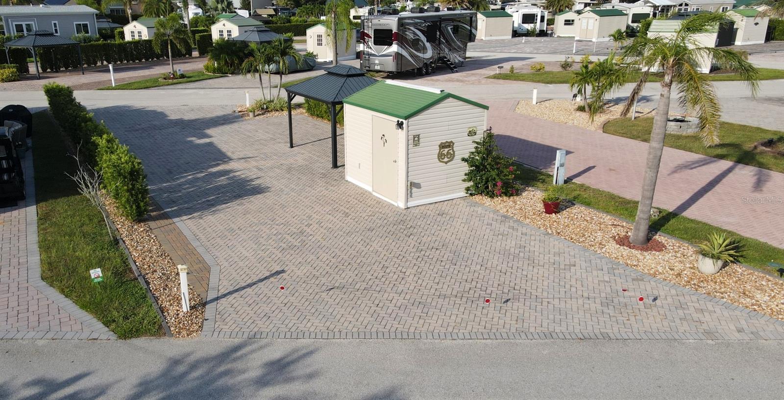 This beautiful brick pavered PULL-THRU RV lot is located within the Elite Resorts at Citrus Valley RV Park, just 8 miles from Disney World and close to shopping and restaurants in beautiful Clermont FL. This particular lot is a full PULL-THRU lot, 2934sf in total size, with the length being about 84.5ft on either side and 40.41ft across the ends. As for location, it doesn't get any better! This lot is located directly across from the Office/Clubhouse/Pool area. Wow!
Included on the lot is approx. 2000sf of pavers, 10x12 shed with electric. Also included is a hard covered gazebo (10x12), plus beautiful landscaping.
Citrus Valley is a gated RV Land Condominium community of 305 privately owned lots, welcoming RV and Park Model units. Citrus Valley is not a 55+ community, but is deed restricted with a Park Manager to ensure quality standards are met and property values are maximized. Park amenities include Clubhouse/Office, two bath houses, laundry facilities, bingo, Veteran's group, and numerous social events, grass is cut regularly on all lots (provided it is accessible), plus water, sewer, trash, cable TV/Internet are included with your quarterly Condo Association dues. Owners also have the option to rent their lot if they wish (however renting is thru each individual owner and not thru the Park Office/Manager).