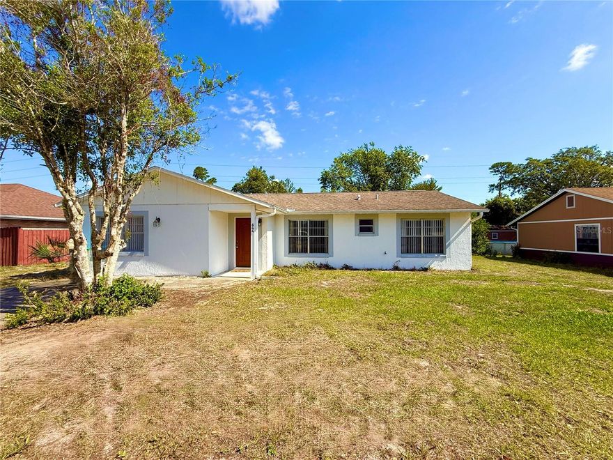 This well-maintained 3 bedroom home in Deltona is perfectly priced and ready for you!  Inside, you will step into a sizable living space that offers room for your large screen TV and comfy couches.  Through to the kitchen where you will find sleek, stainless steel appliances and plenty of cupboard space.  The bedrooms are on a split plan with the large primary bedroom and private bathroom on one side and the guest rooms on the other.  The primary suite has a walk in shower and is easy to get in and out of.  The guest rooms are ideally sized with good closet space. Inside there is a bonus room that would be perfect for an extra bedroom, playroom or office.  Out of the sliding glass doors off of the main living area you will find a covered, enclosed rear porch.  Open up the sliding windows to let in the air or keep them closed during the cooler months.  There is a HUGE detached outbuilding that has a 1 garage and 2 carports.  This space provides endless possibilities for a workshop, extra storage or hobby space.  Conveniently located close to major highways, shopping, restaurants, medical, public transportation and more!