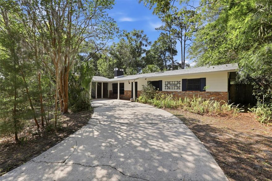 One or more photo(s) has been virtually staged. Charming 3 bedroom, 2 bath home in desirable Palm View Estates offering 1,774 square feet on a .27 acre lot in the heart of Gainesville. Built in 1965, this cozy home has seen numerous updates over the years including updated wiring, water pipes, interior paint, LVP flooring in the spacious rear great room, plus a newer roof and water heater. Inside, you’ll find a blend of character and comfort with terrazzo flooring in several rooms, a cozy wood-burning fireplace, and large windows in the great room overlooking lush landscaping, creating the perfect spot to enjoy blooming plants and visiting birds. The enclosed side porch provides additional flexible space, while the side patio area offers room for a future garden or outdoor retreat. Conveniently located close distance to shopping, the library, gym, and close to the hospital, University of Florida, and Santa Fe College. Centrally located with easy access to everything Gainesville has including parks! Ready for its next homeowner to add their own personal touches and make it their own.